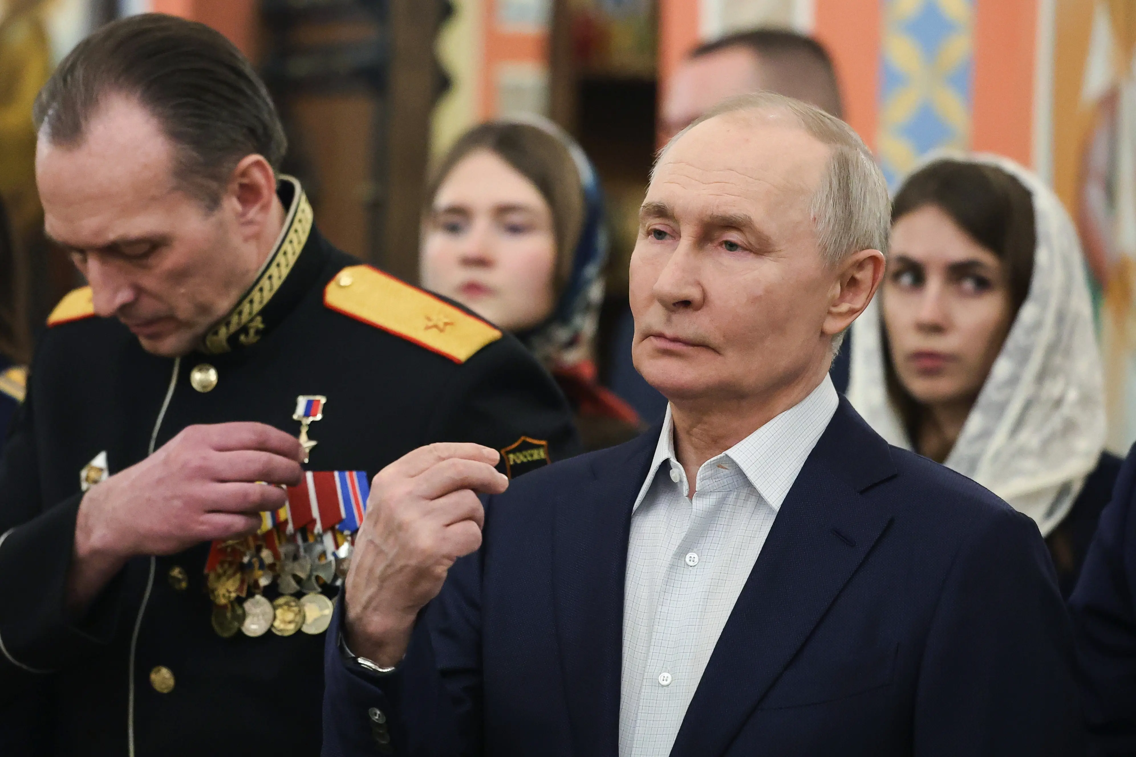 Russian President Vladimir Putin, right, accompanied by military personnel and their families, crosses himself during the Orthodox Christmas service at the Church of Great-Martyr St. George the Victorious in Solnechnogorsk-2, outside Moscow, on Wednesday, Jan. 7, 2026. | Photo: AP