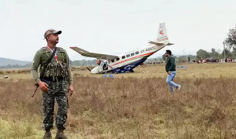 A security person stands guard at the site of IndiaOne Air nine-seater aircraft accident after it crash-landed with passengers & crew onboard near the Jalda area, in Rourkela | ANI