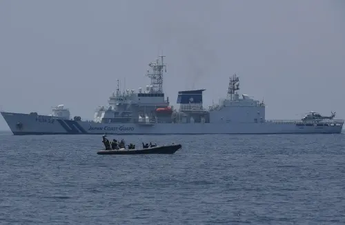 Philippine coast guard personnel aboard a rigid hull boat speed past the Japanese coast guard ship Akitsushima during a maritime exercise with Japan and the US in the South China Sea off Mariveles town, Bataan province on June 6, 2023 | Photo: AFP