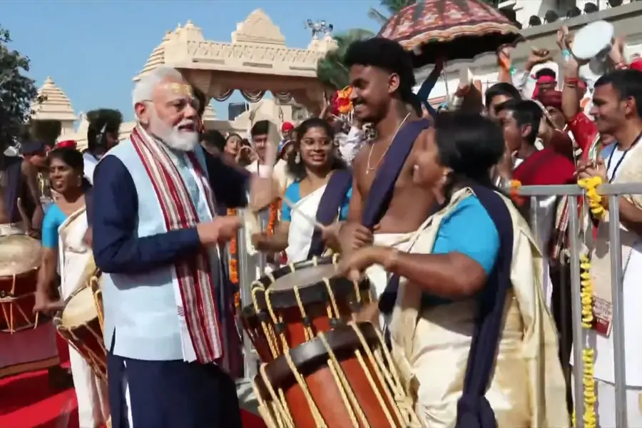 PM Modi tries the chenda and interacts with artists in attendance at the event
