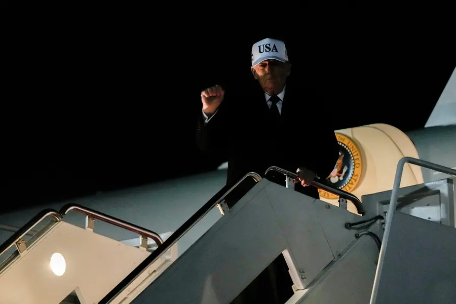 President Donald Trump gestures while disembarking Air Force One after returning from Florida