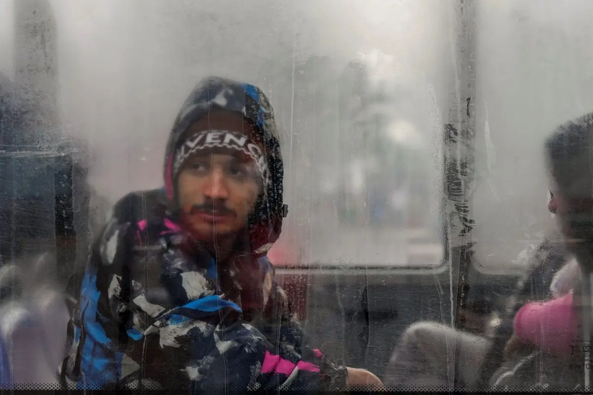 A passenger looks through a window on a cold winter morning, in New Delhi