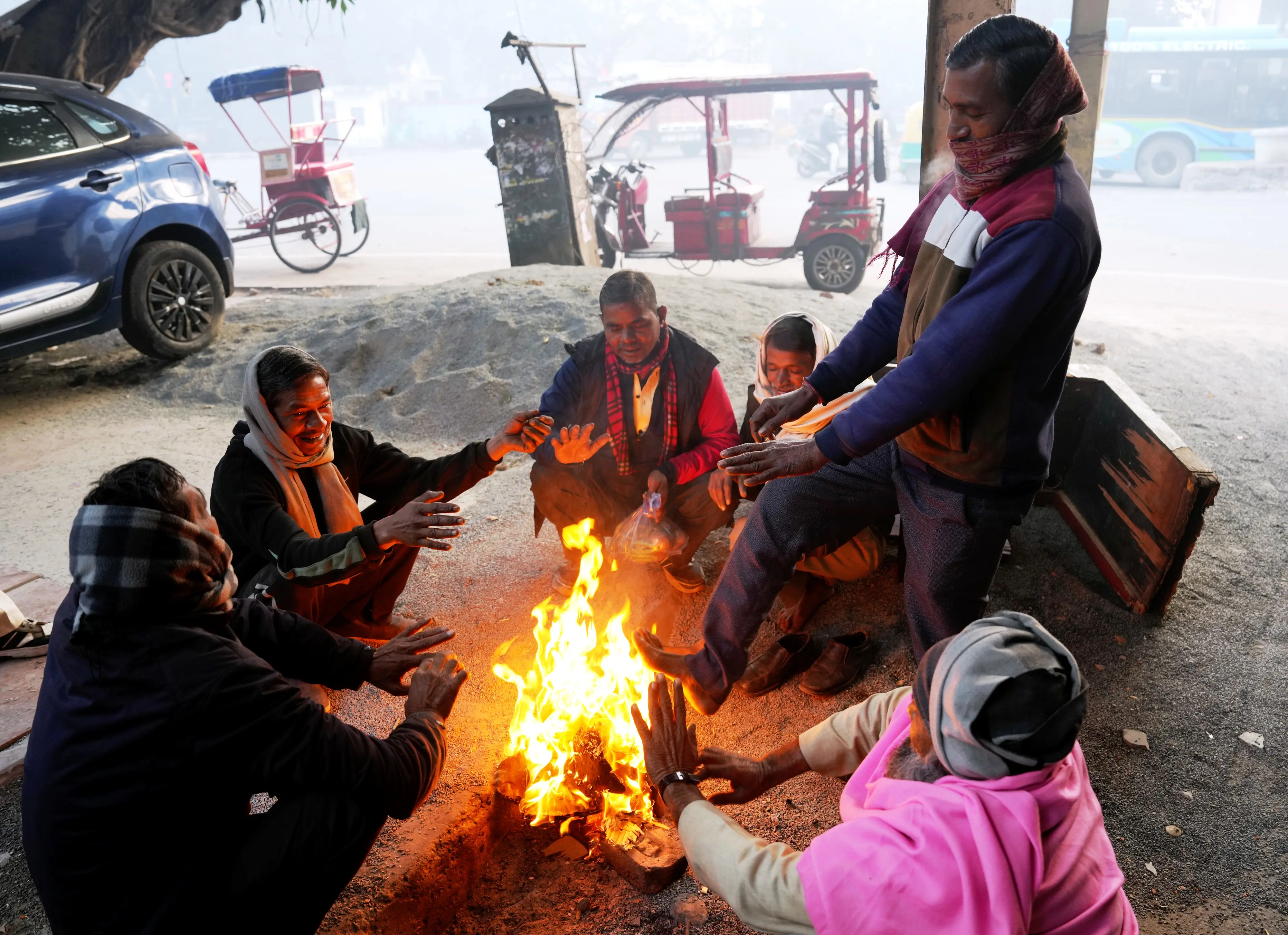 People warm themselves around a small fire as cold weather conditions prevail, in New Delhi | Photo: PTI