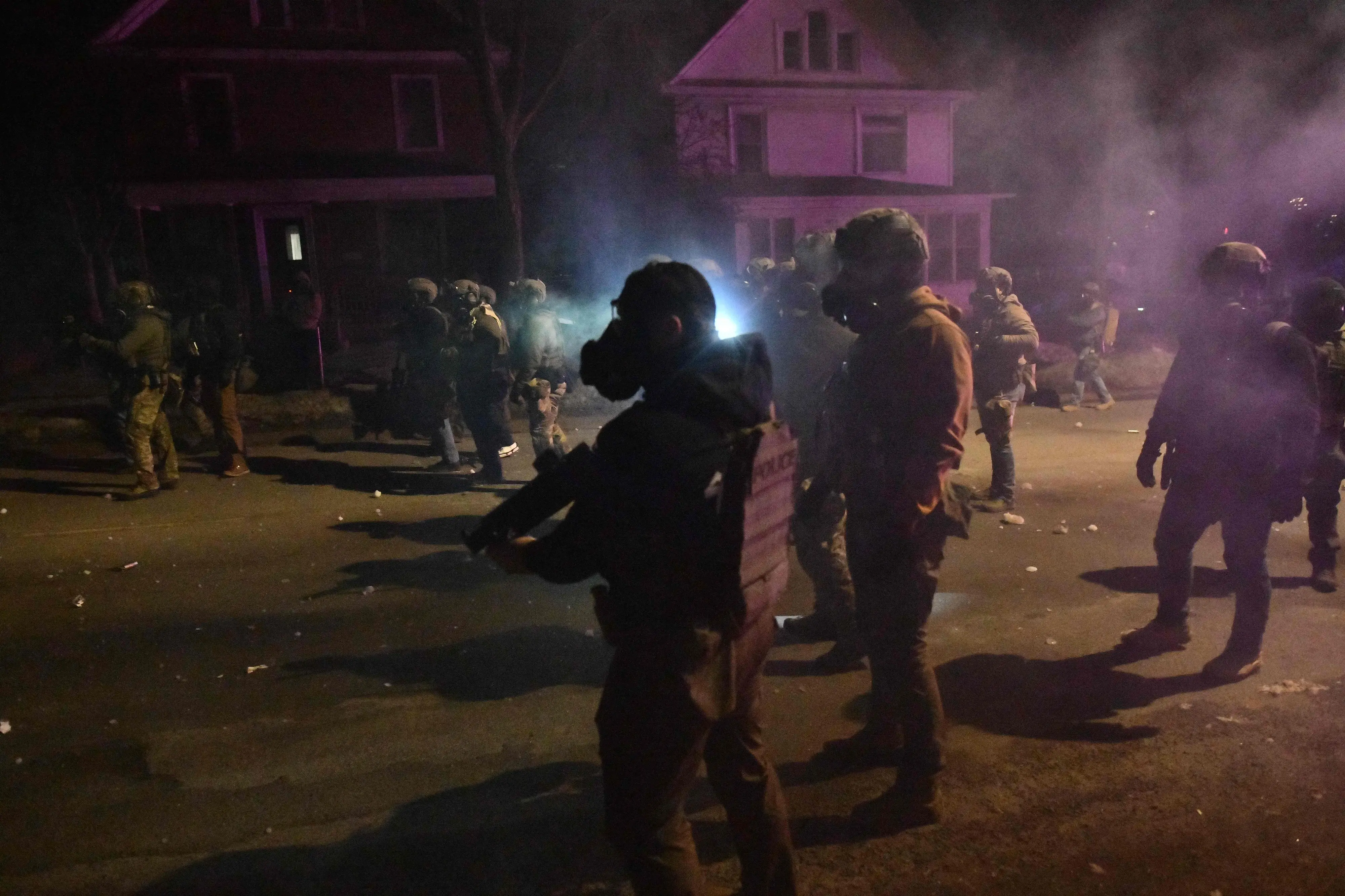 Federal law enforcement agents and police officers in riot gear walk amid smoke from crowd-control devices after protests broke out following the shooting of a Venezuelan man by a Immigration and Customs Enforcement (ICE) agent in Minneapolis, Minnesota, on January 14, 2026.| Photo: AFP