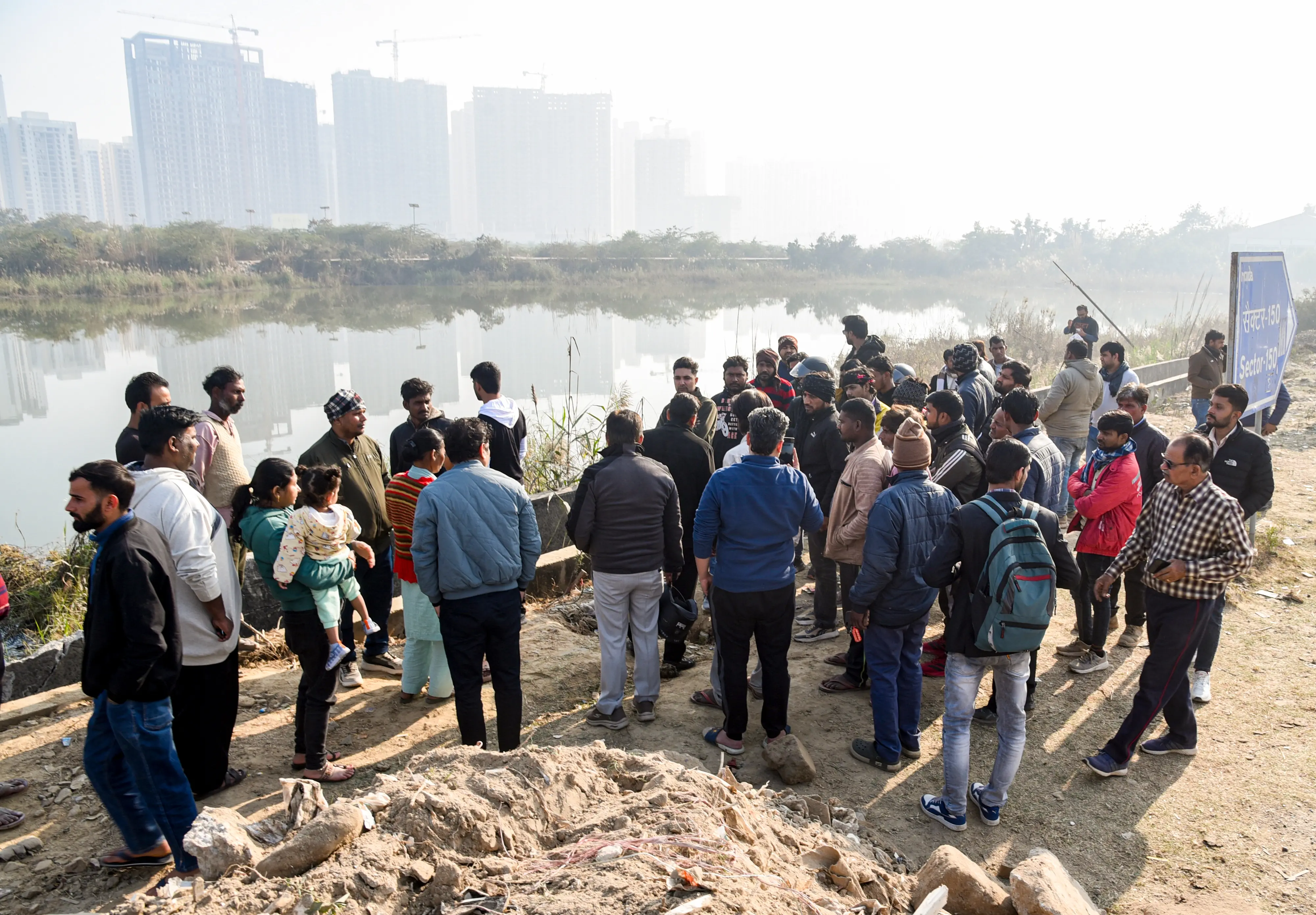 People gather during a search operation after a 27-year-old software engineer died on Saturday after his car went out of control and fell into a 20-foot-deep water-filled pit | PTI