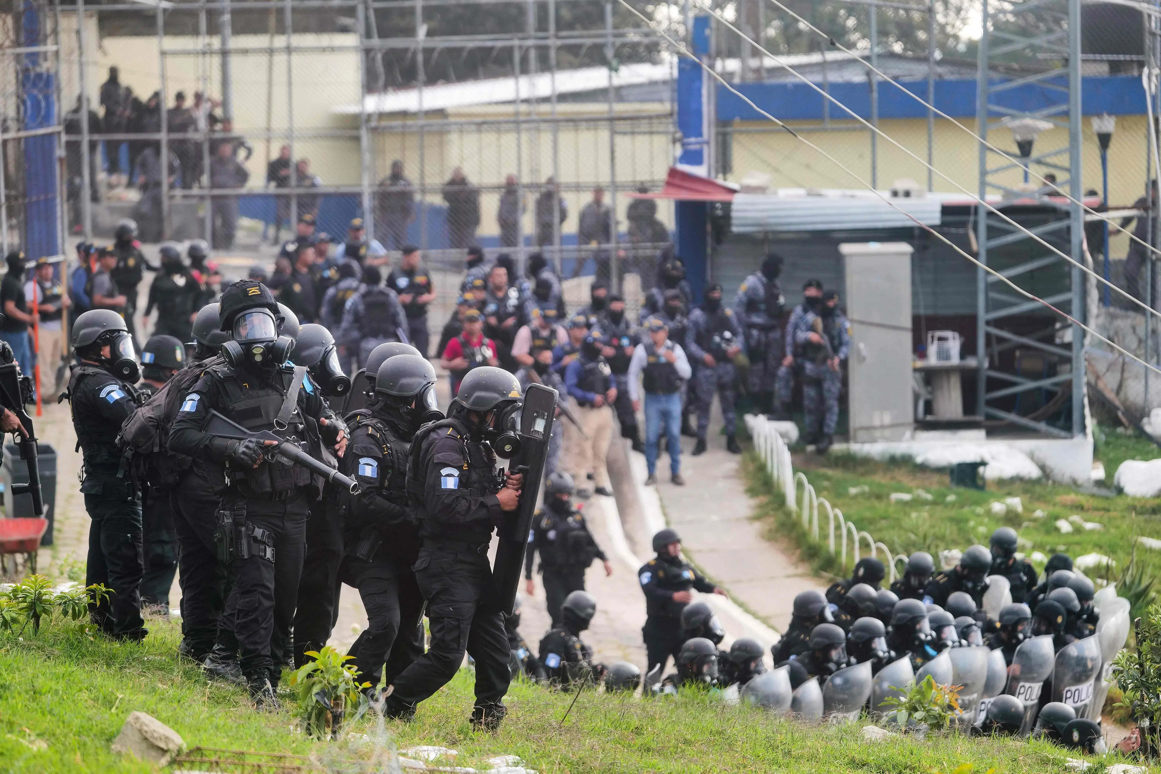 Guatemalan riot police officers guard the entrance to the men's Preventive Detention Center in Guatemala City | Photo: AFP