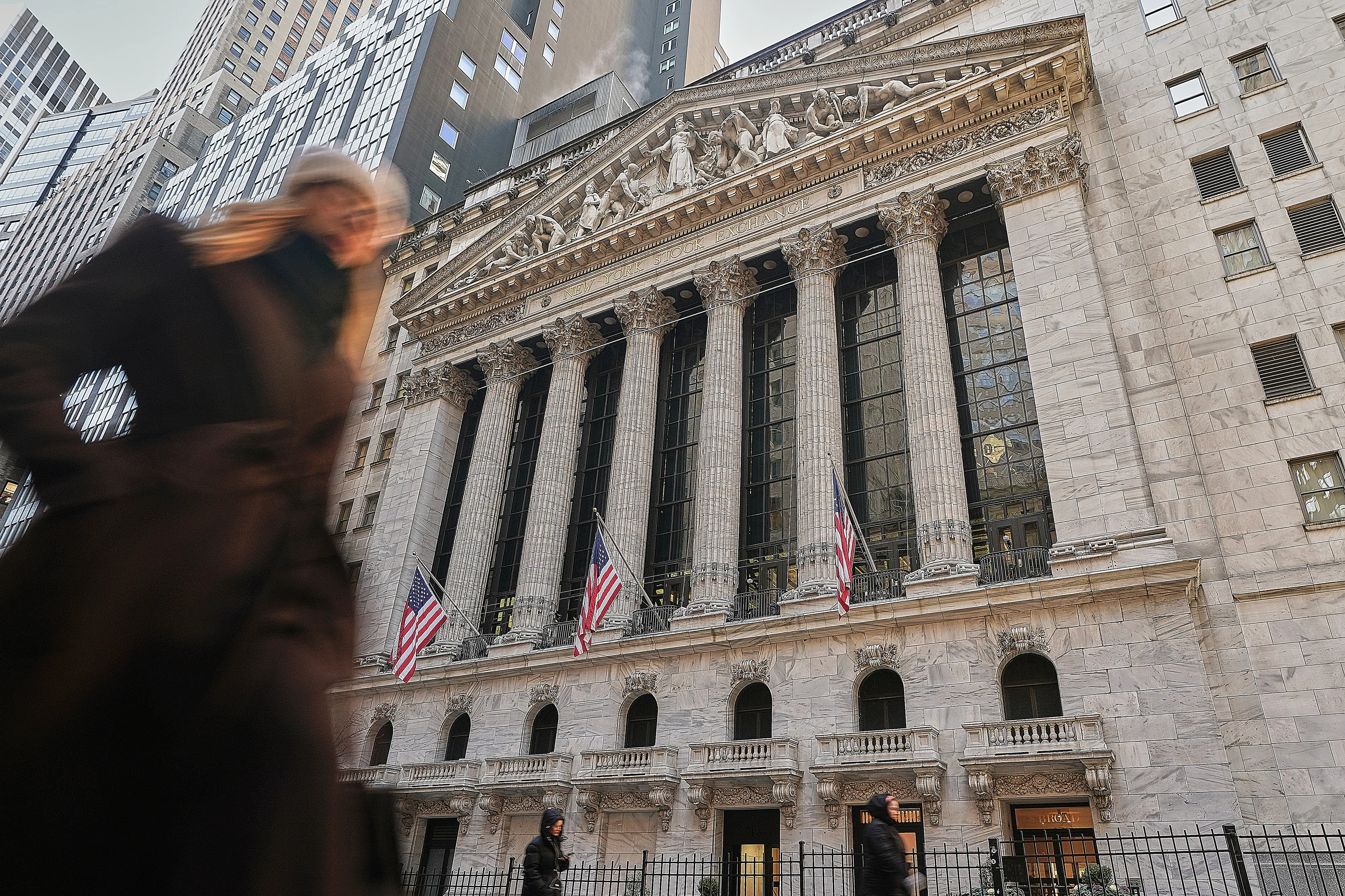 Morning commuters pass the New York Stock Exchange | AP