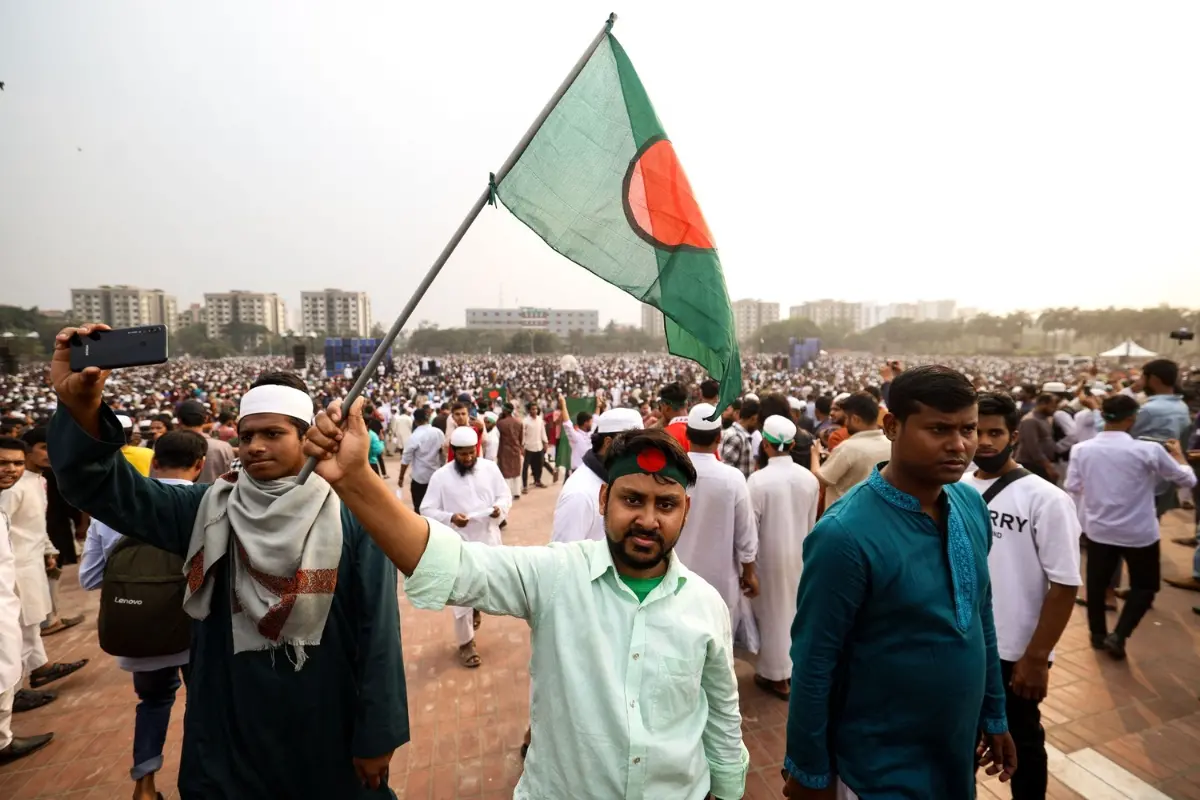 File Photo: Mourners wave Bangladesh's national flag during the funeral of student leader Sharif Osman Hadi in Dhaka on December 20, 2025 | AFP