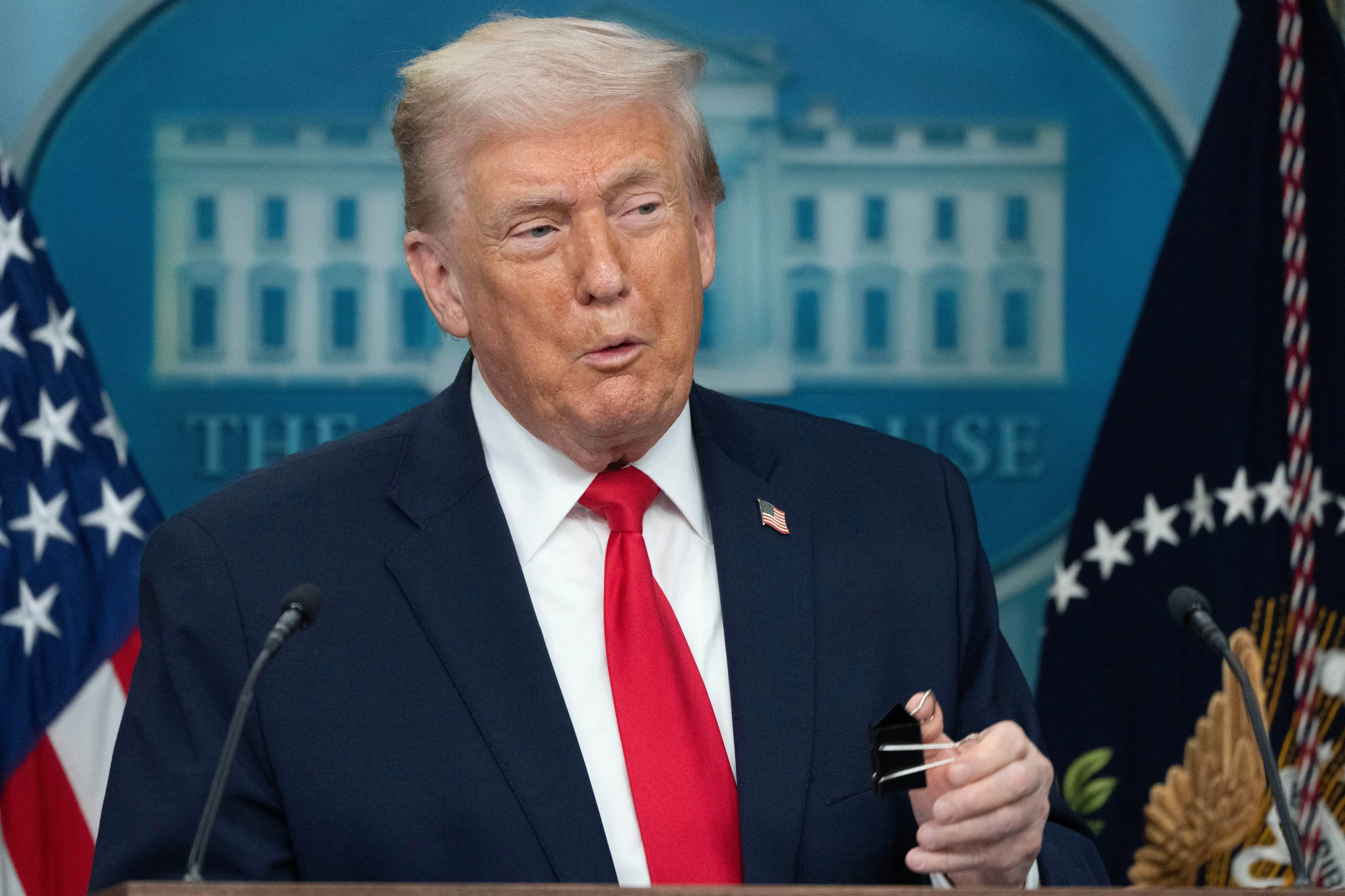 President Donald Trump holds a binder clip as he speaks during a press briefing at the White House in Washington | Photo: AP
