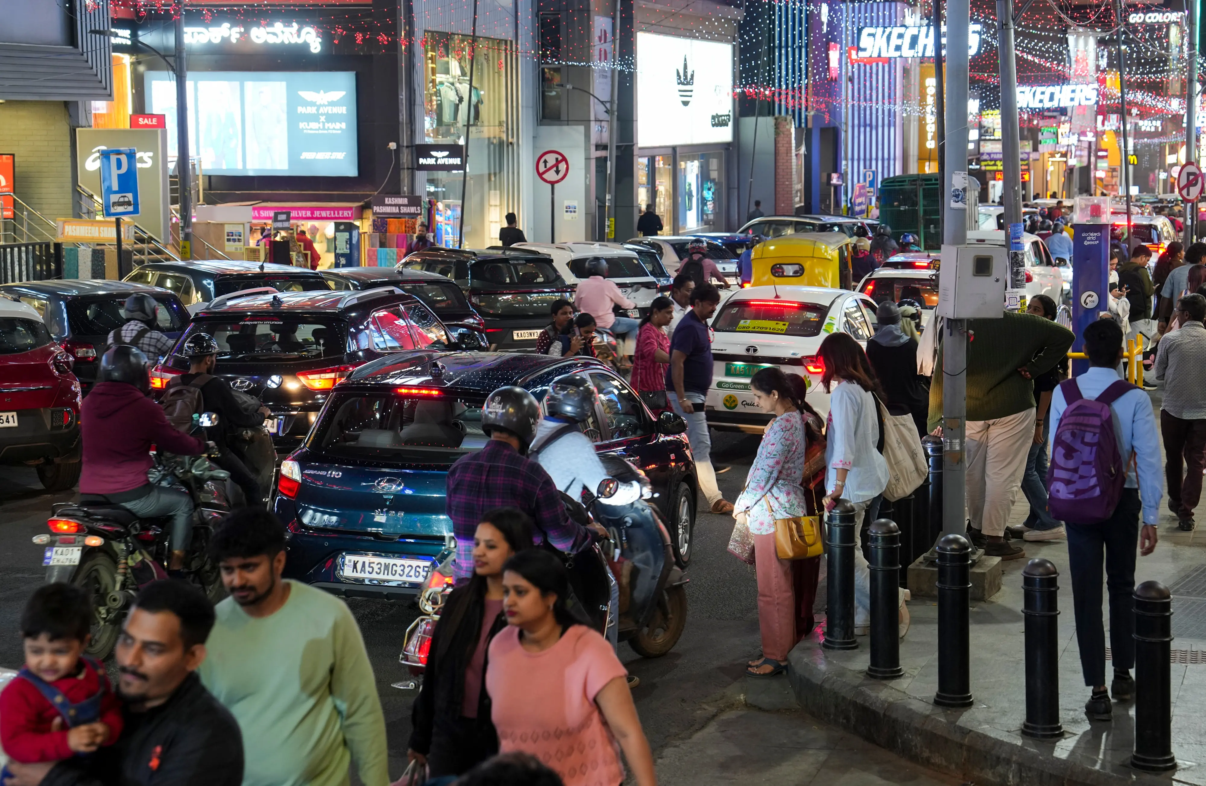 People cross a road amid traffic near Church Street in Bengaluru | Photo: PTI