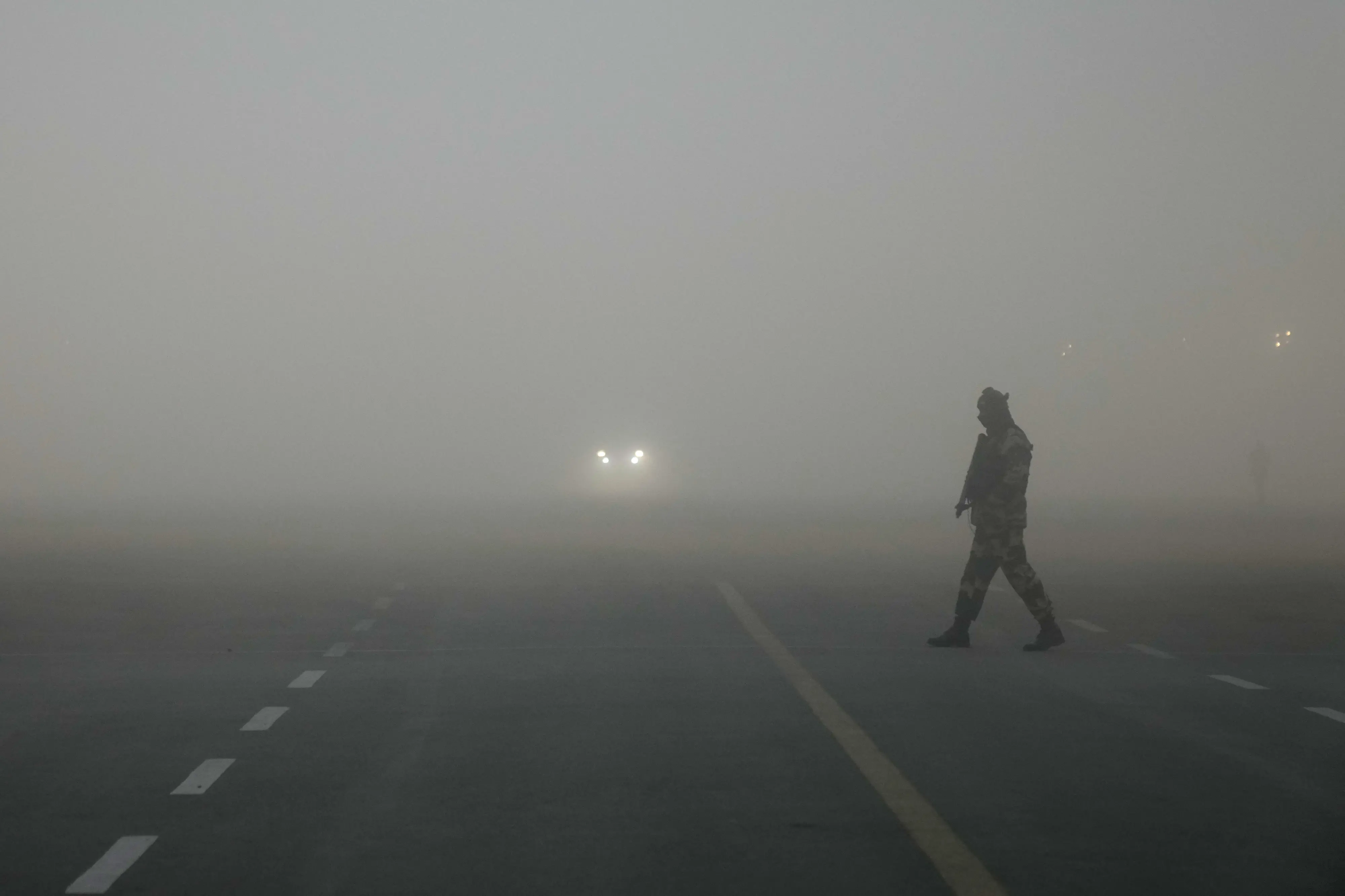An Indian para-military soldier walks across a street at Raisina hills amidst early morning smog | Photo: AP