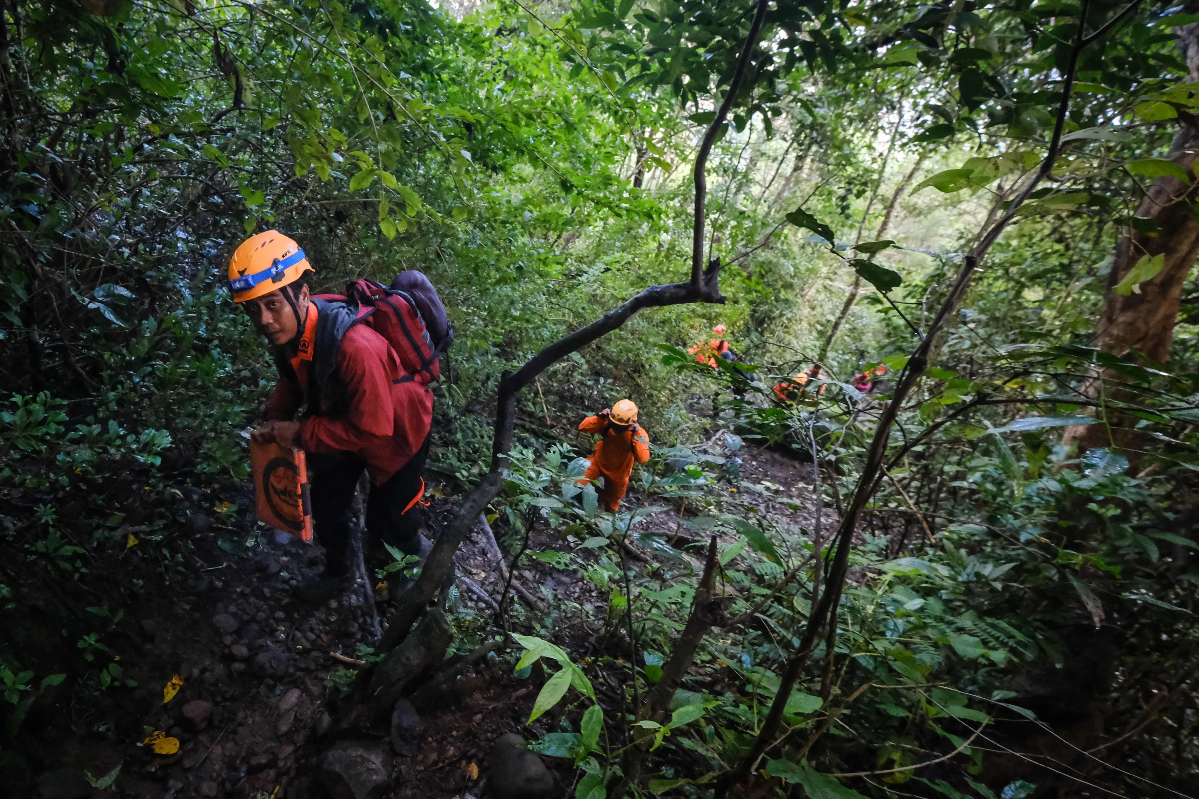 Joint search and rescue teams climb towards the suspected crash site of an Indonesia Air Transport turboprop plane | Photo: AFP