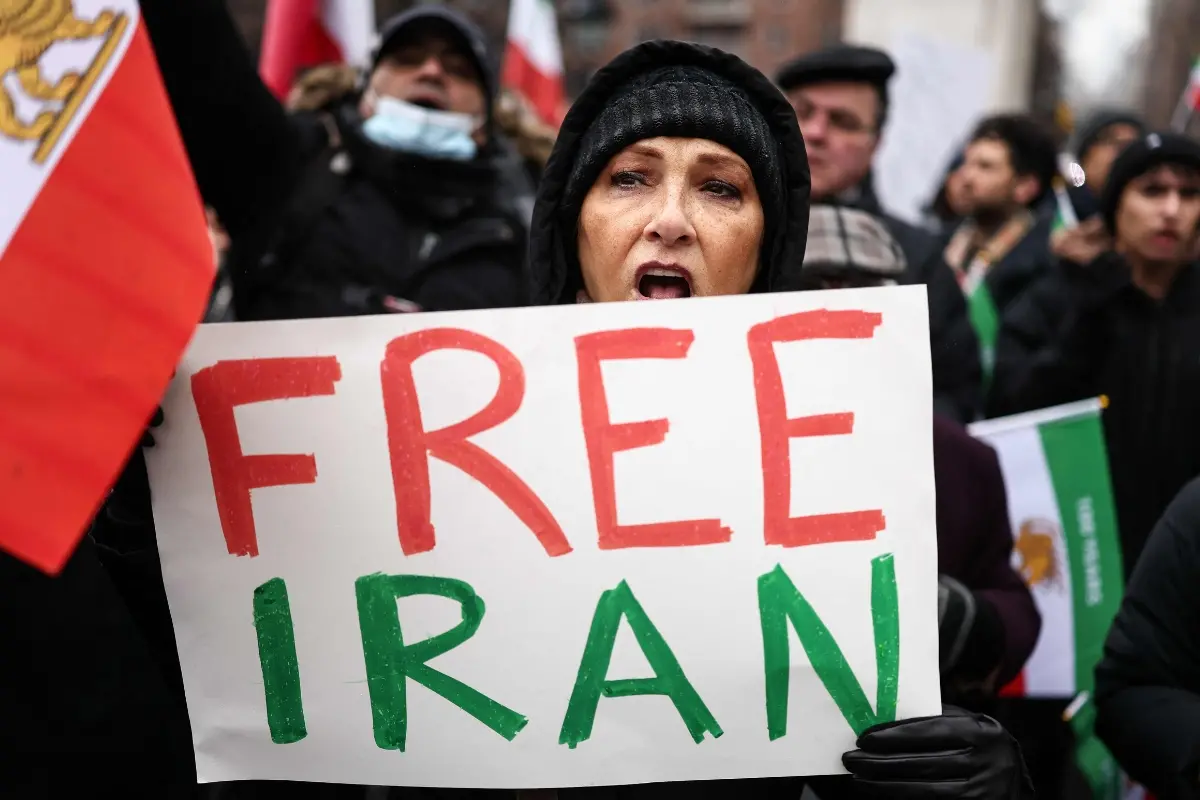File: A woman holds a 'Free Iran' sign as people sing and shout during a rally in support of the Iranian people in New York | Photo: AFP