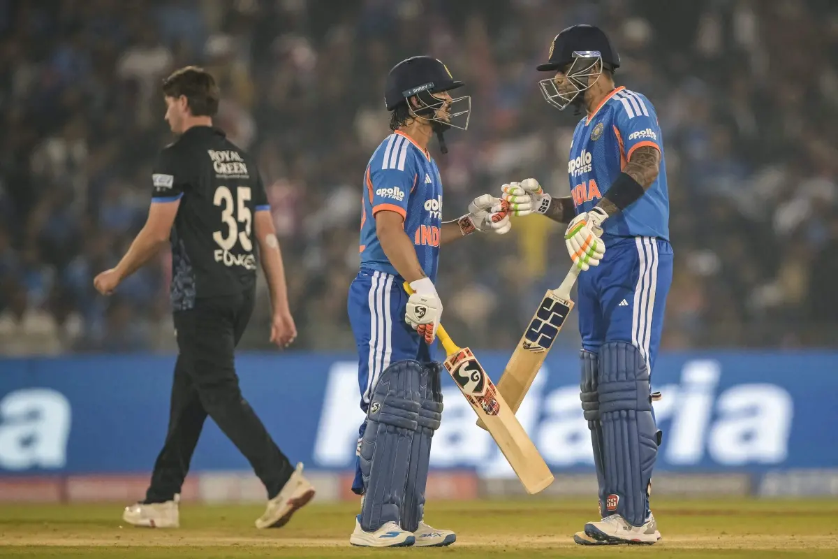 Ishan Kishan (C) and captain Suryakumar Yadav (R) bump their fists during the second Twenty20 international cricket match between India and New Zealand at the Shaheed Veer Narayan Singh International Cricket Stadium in Raipur. | Photo: AFP