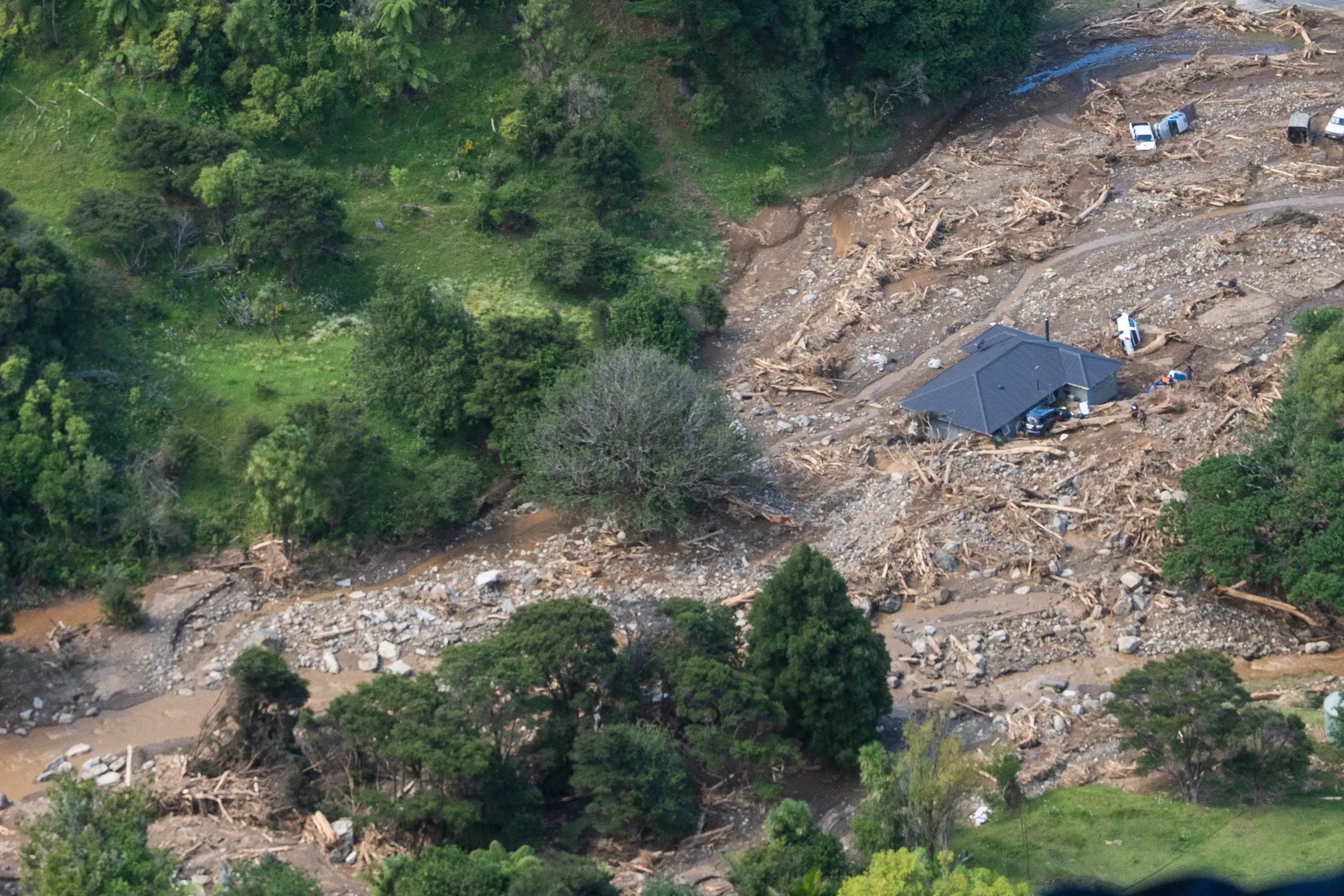 A damaged house and cars are some of the debris shown on Friday, Jan. 23, from a landslide at Te Areroa, New Zealand | Photo: AP