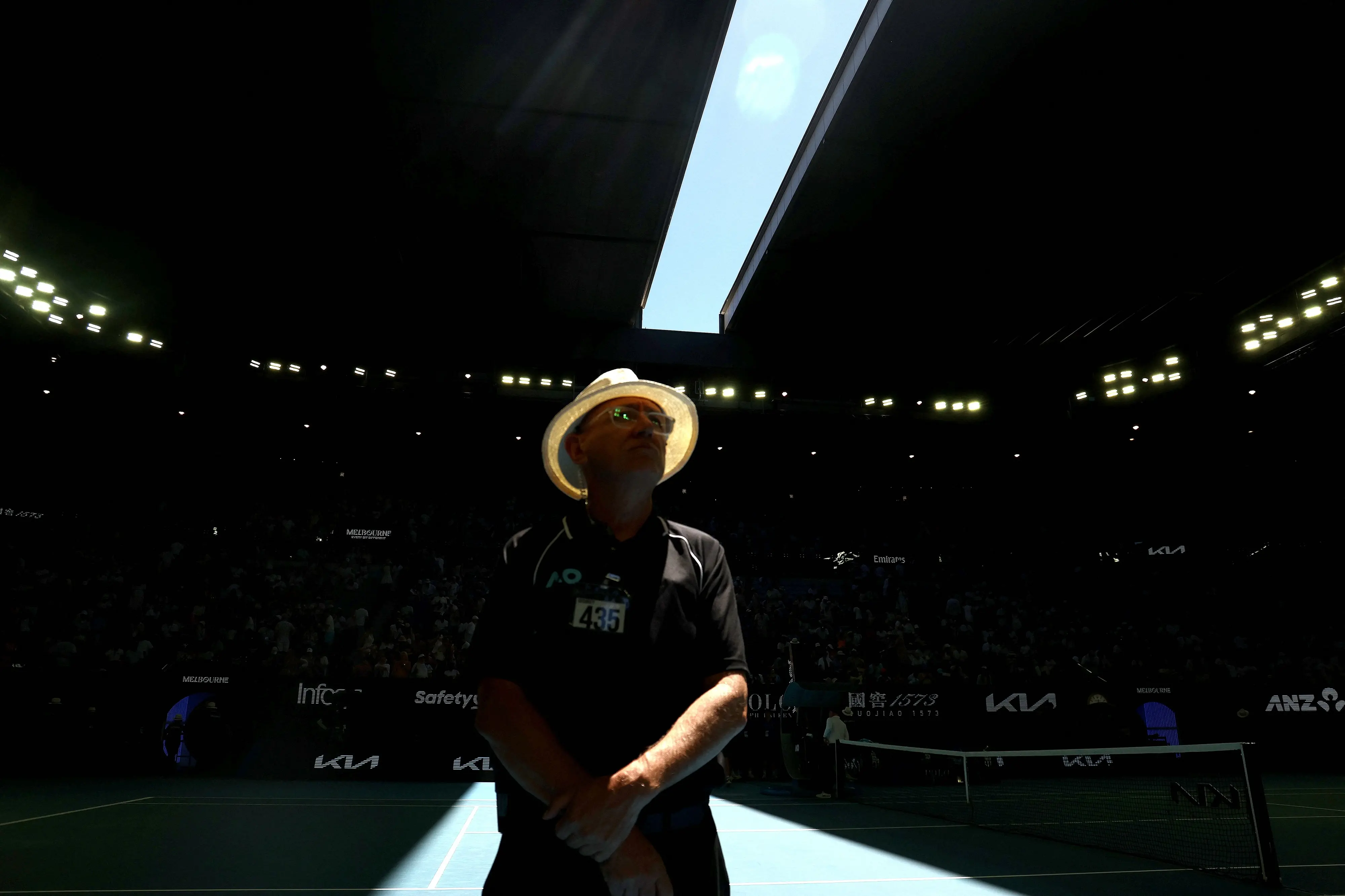 A security officer looks on as the roof of Rod Laver Arena is closed due to extreme heat during the men's singles match between Italy's Jannik Sinner and USA's Eliot Spizzirri on day seven of the Australian Open tennis tournament in Melbourne | Photo: AFP