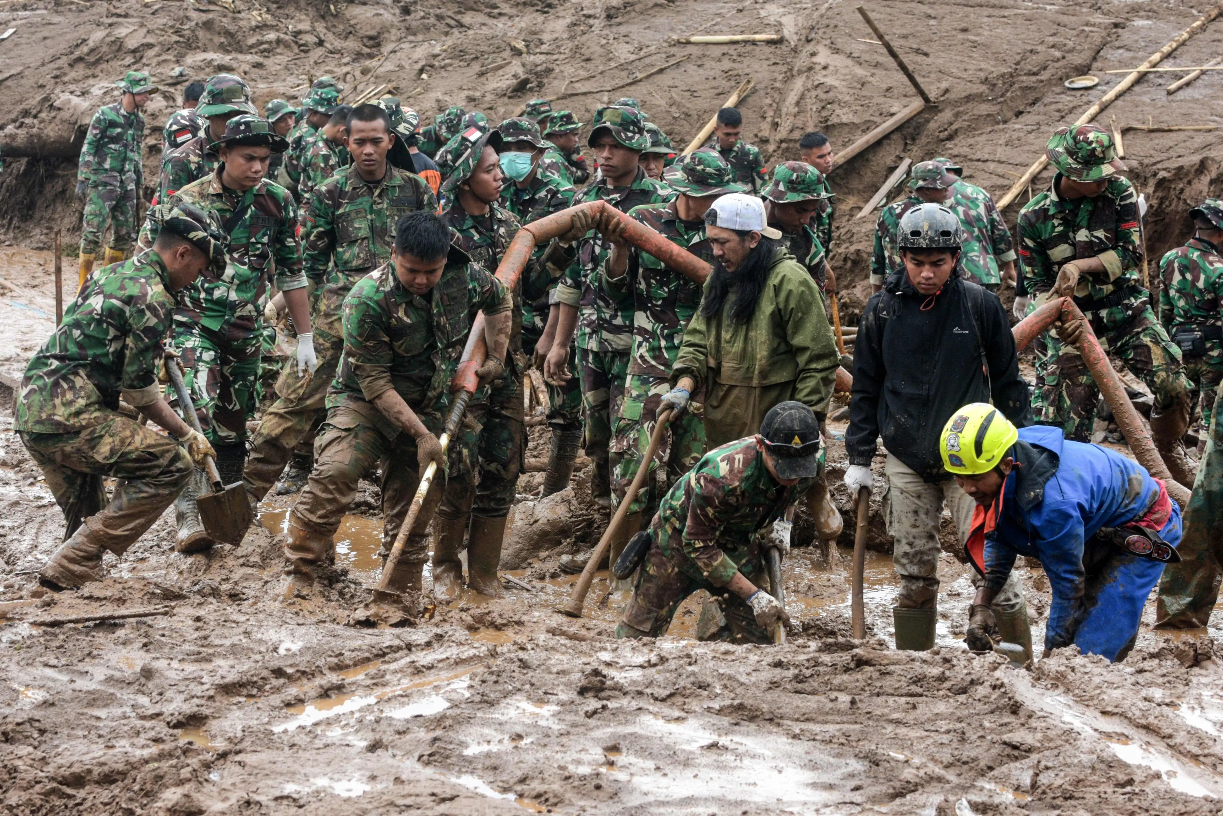 Rescuers search for victims buried by a landslide in Pasirlangu village in Bandung, West Java | Photo: AFP