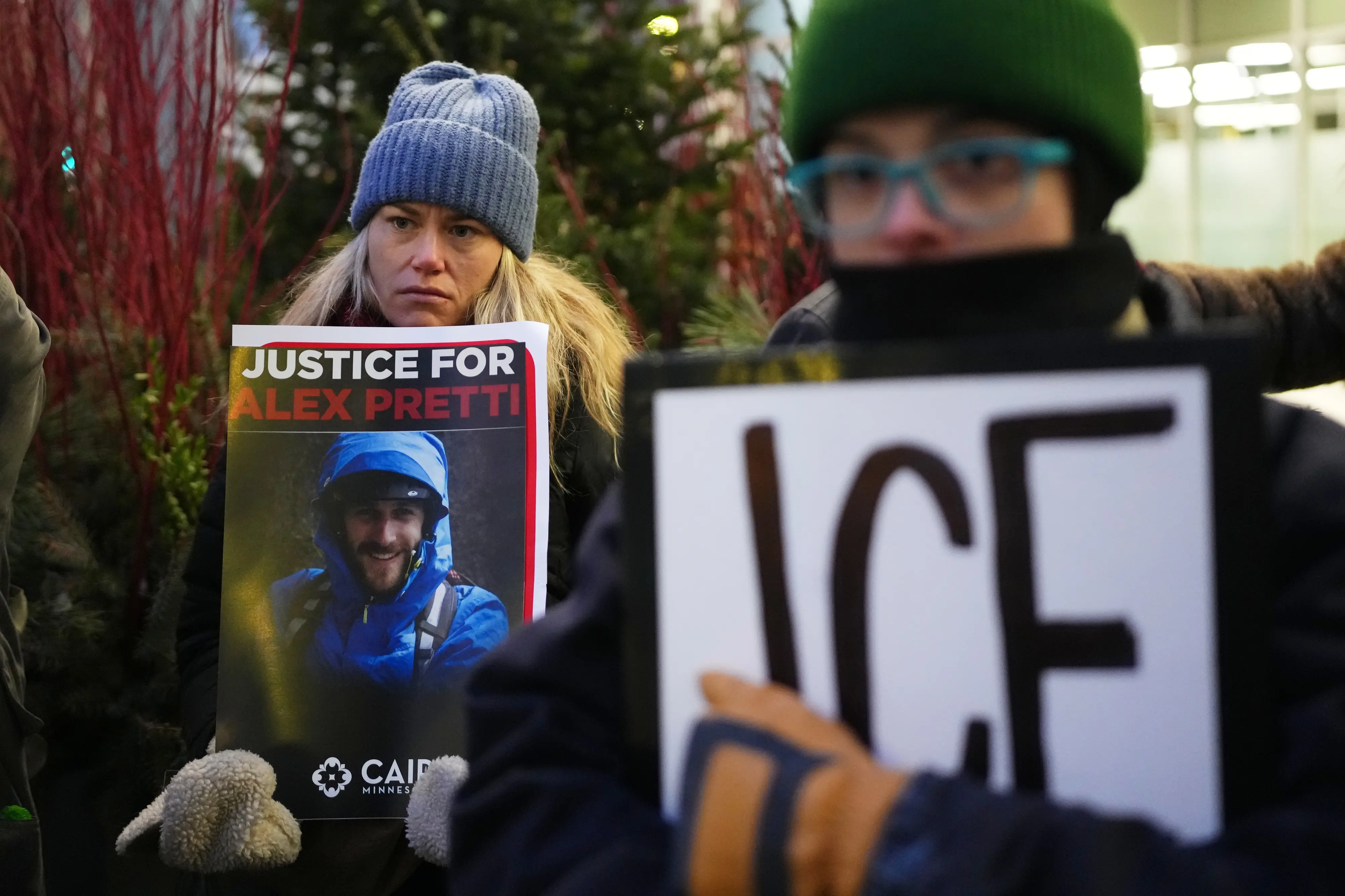 Demonstrator holds signs during a protest outside the office of Sen. Amy Klobuchar, D-Minn., on Monday, Jan. 26, 2026, in Minneapolis | AP