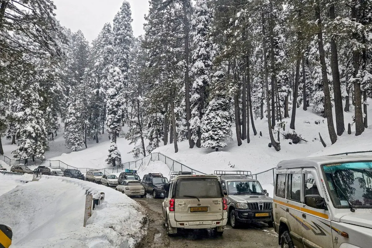 Vehicles move on the snow-covered Tangmarg-Gulmarg road after fresh snowfall in Gulmarg, Baramulla district, on Monday, January 26, 2026. (PTI Photo)