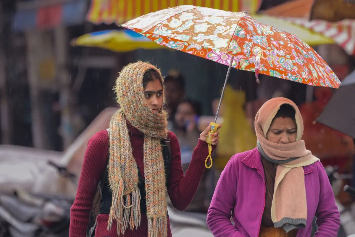 Commuters donned warm clothes and carried umbrellas as a cold wave and rainfall sent temperatures plummeting in Jalandhar on Tuesday | Photo: ANI