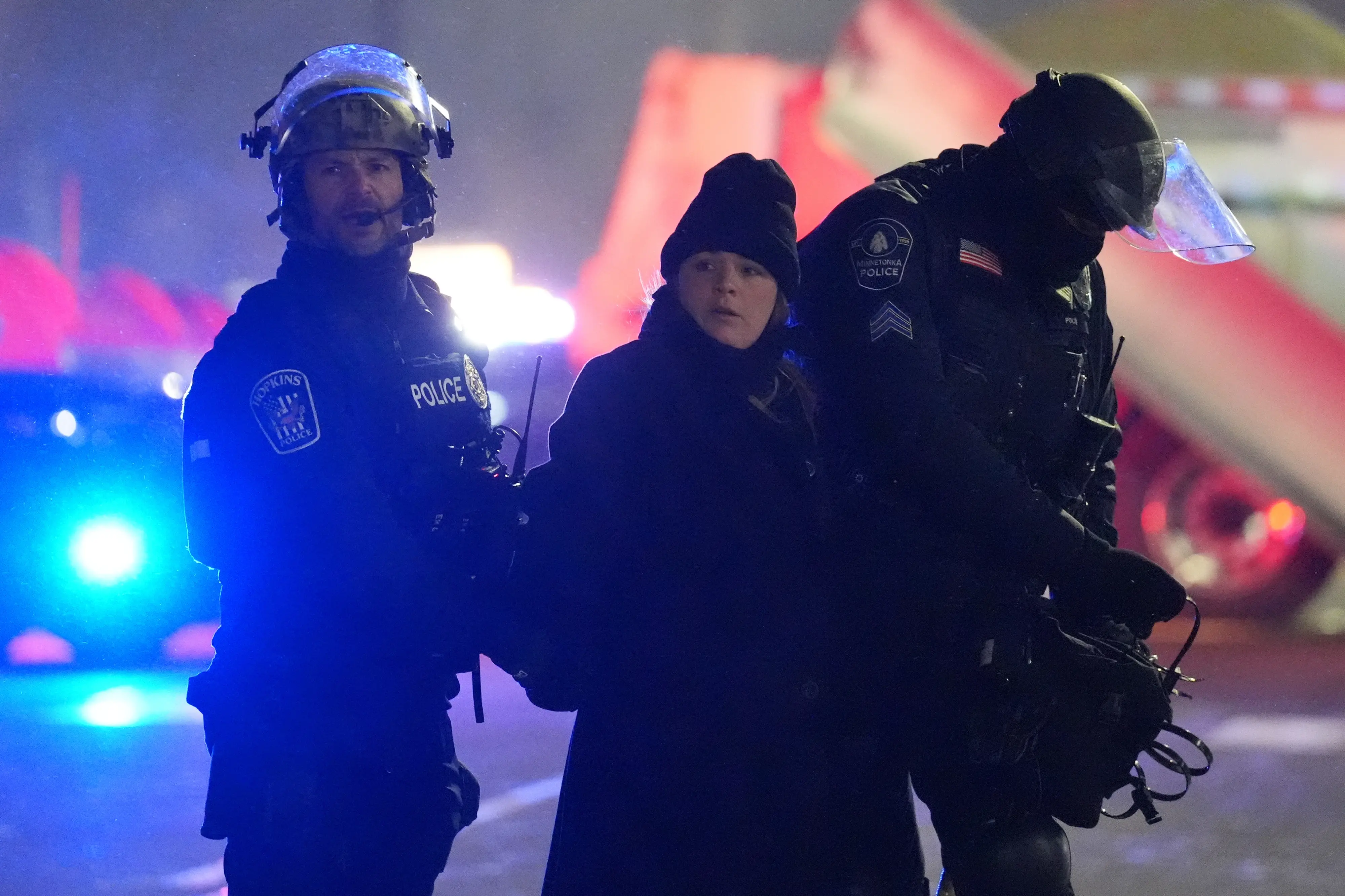 Law enforcement officers detain a person during a protest | AP