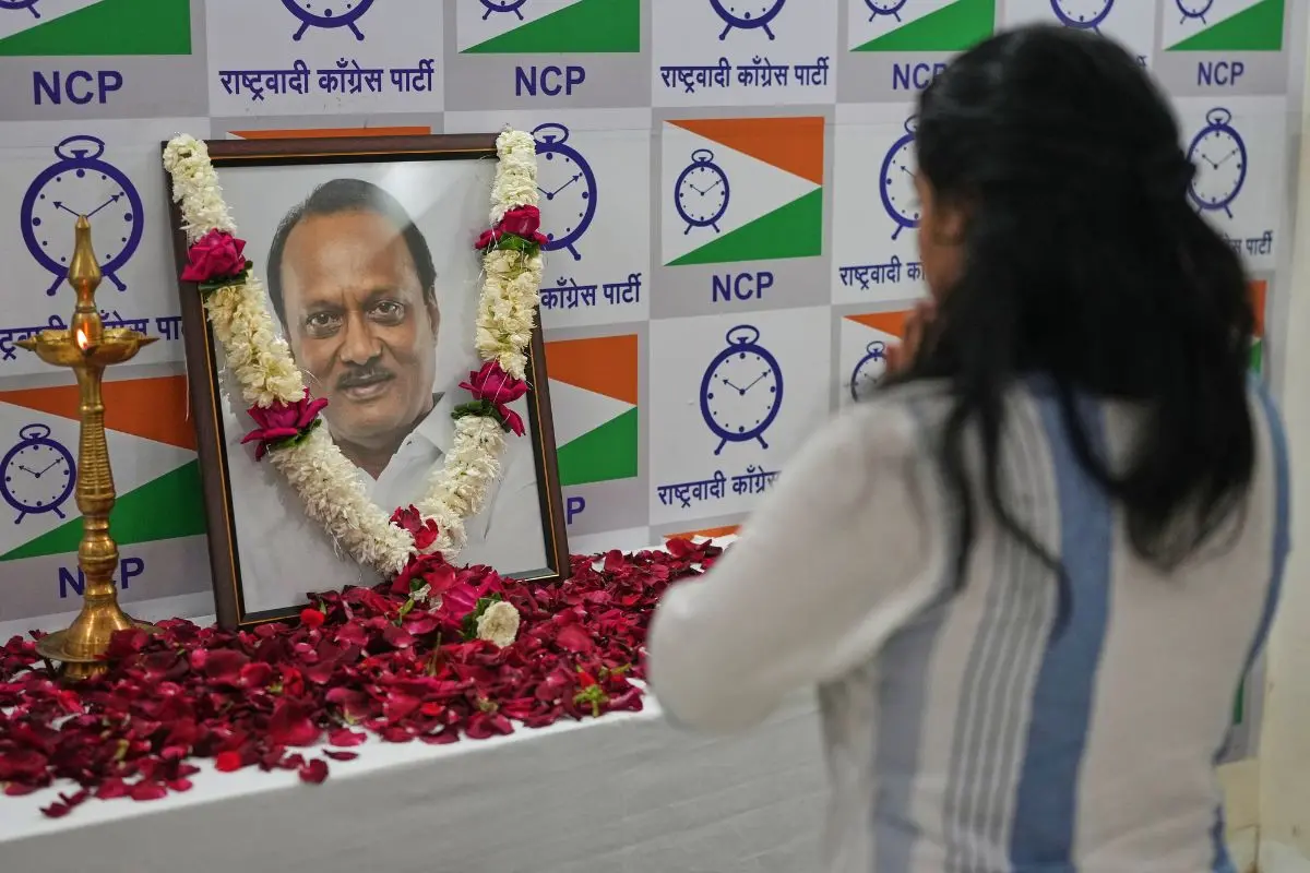 A supporter of Maharashtra Deputy Chief Minister Ajit Pawar pays homage near his photograph at the Nationalist Congress Party office in Mumbai | Photo: AP