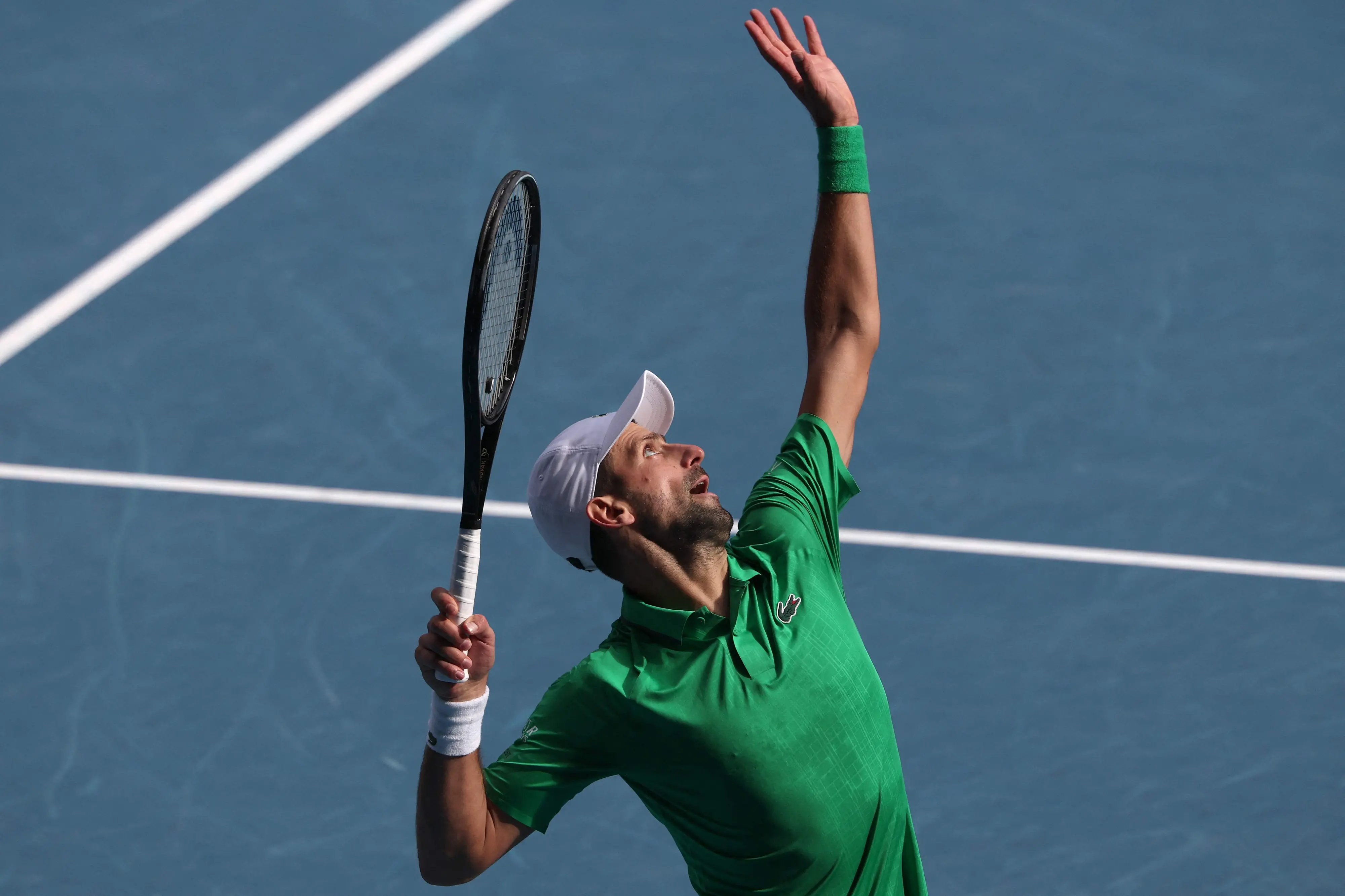Serbia's Novak Djokovic serves to Italy's Lorenzo Musetti during their men's singles quarter-final match on day eleven of the Australian Open tennis tournament in Melbourne | Photo: AFP
