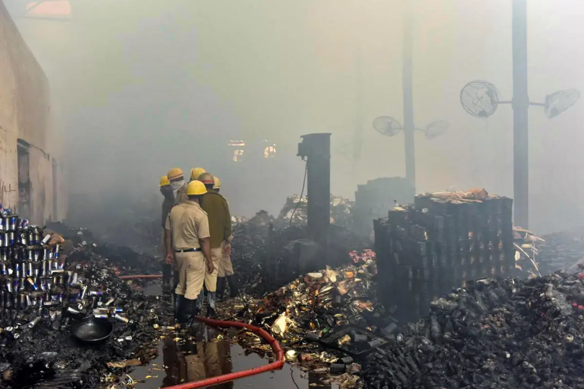 Fire brigade personnel douse a fire at a warehouse, in Kolkata