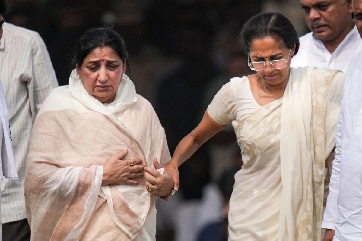 unetra Pawar, left, pays last respects to the mortal remains of his husband and Maharashtra Deputy Chief Minister Ajit Pawar during his funeral, at the Vidya Pratishthan ground, in Baramati, Pune district, Thursday, Jan. 29, 2026. NCP (SP) leader Supriya Sule is also seen. (PTI Photo/Kunal Patil)