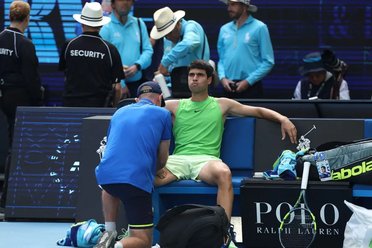 Carlos Alcaraz receives medical attention during his men's singles semi-final match against Germany's Alexander Zverev on day thirteen of the Australian Open tennis tournament in Melbourne on January 30, 2026. (Photo by Martin KEEP / AFP)