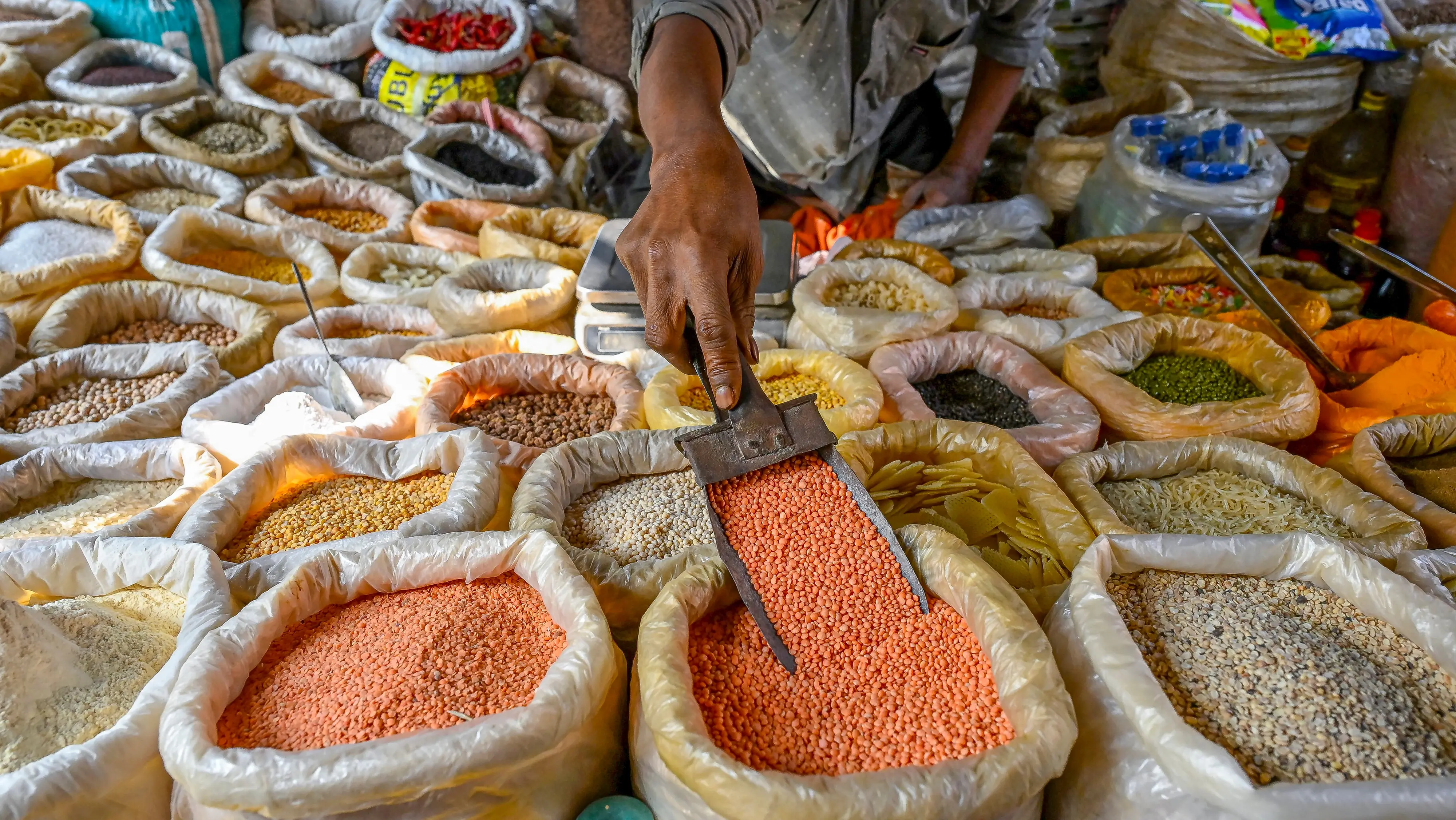 A vendor sells pulses at a weekly market | PTI