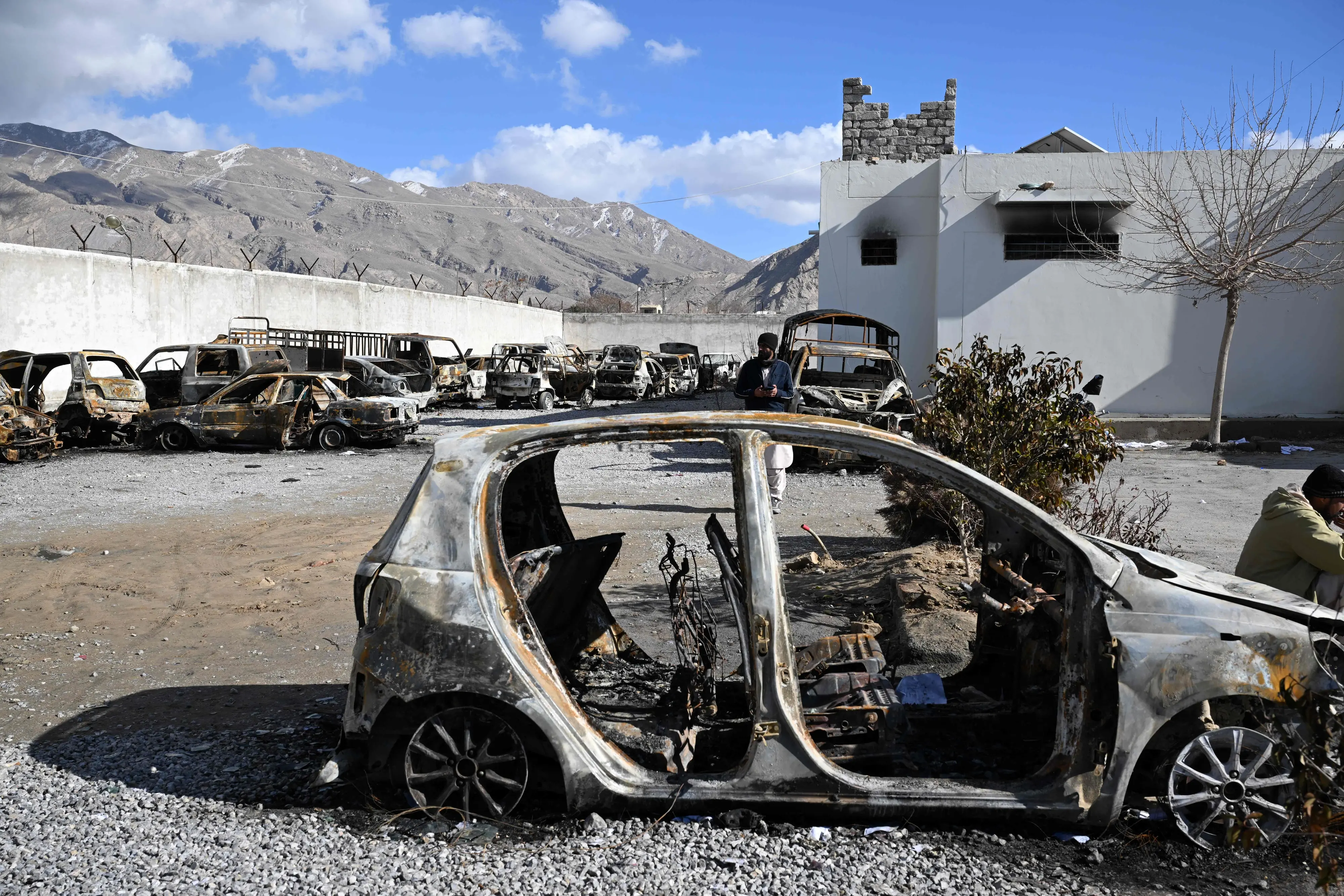A man stands beside burnt vehicles inside a torched police station on the outskirts of Quetta, a day after an attack by Baloch separatists | Photo: AFP