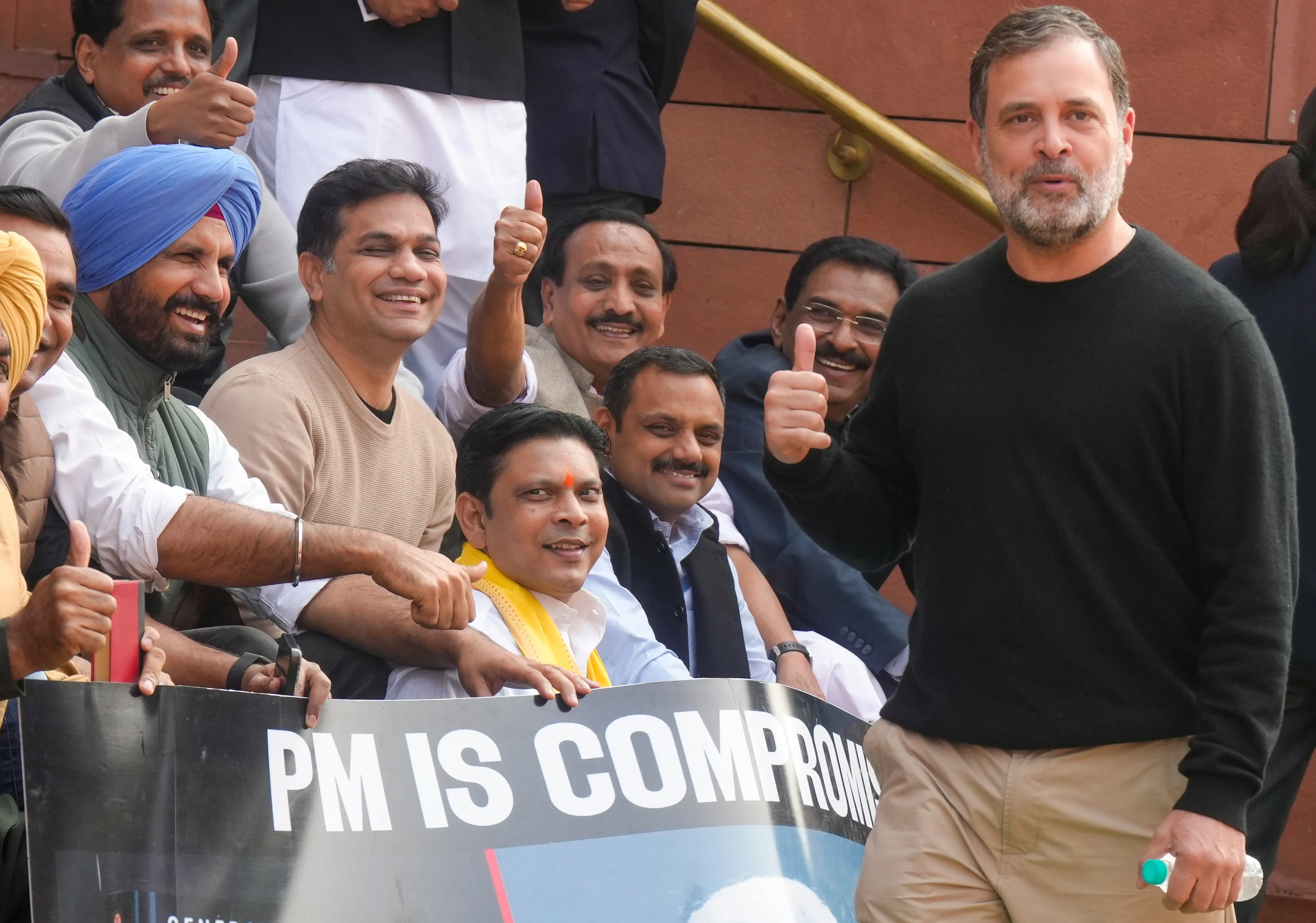 Leader of Opposition in the Lok Sabha Rahul Gandhi with Lok Sabha MPs who were suspended on Tuesday for the remainder of the Budget session for 'unruly behaviour', as they stage a protest with a poster ''PM is compromised'', at Parliament premises in New Delhi | Photo: PTI