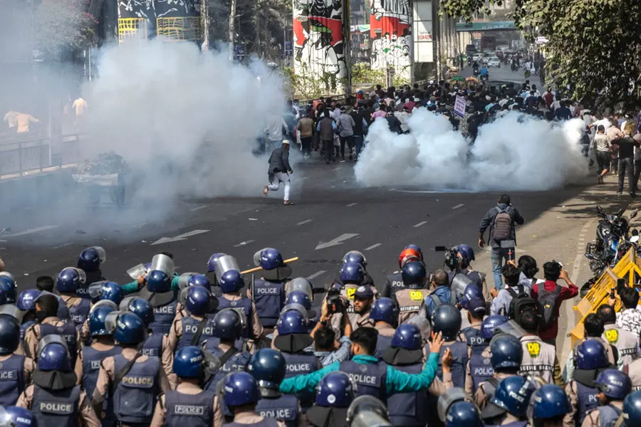 Police personnel fire tear gas shells to disperse government employees demanding implementation of the new pay scale during a protest in Dhaka