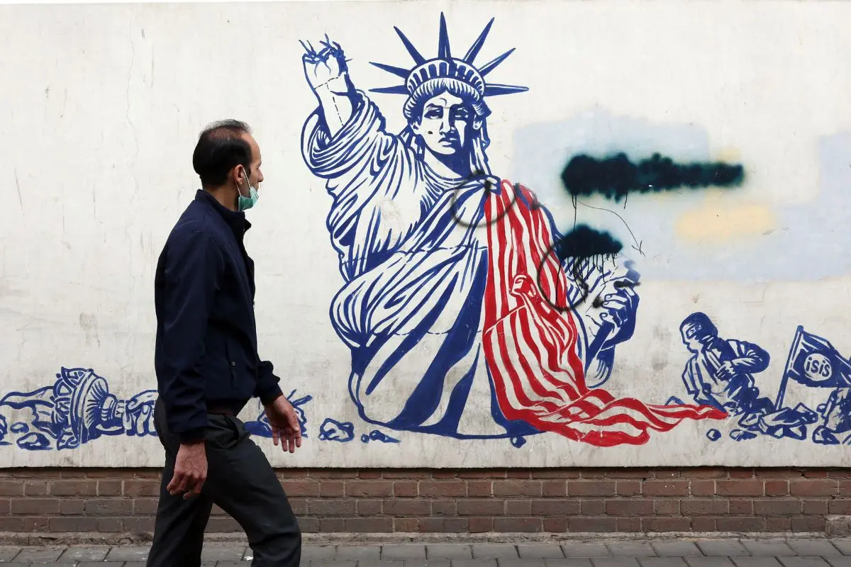 A man walks past a mural depicting the US Statue of Liberty with the torch-bearing arm broken, painted on the outer walls of the former US embassy, in Tehran on February 6, 2026 (Photo: AFP)