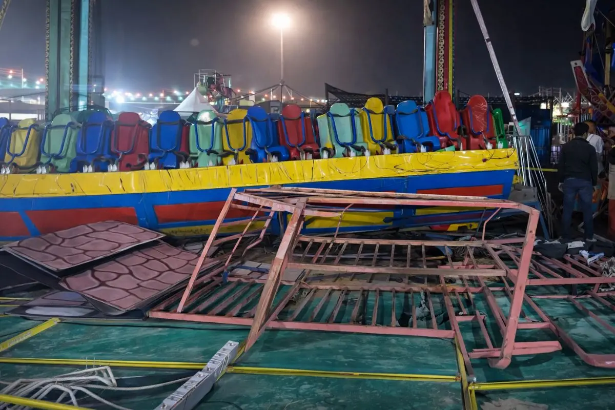 Twisted metal barricades and a damaged swing ride lie strewn at the Surajkund International Crafts Mela in Faridabad after the amusement ride collapsed on Saturday night, killing one and injuring several others. (PTI Screengrab)