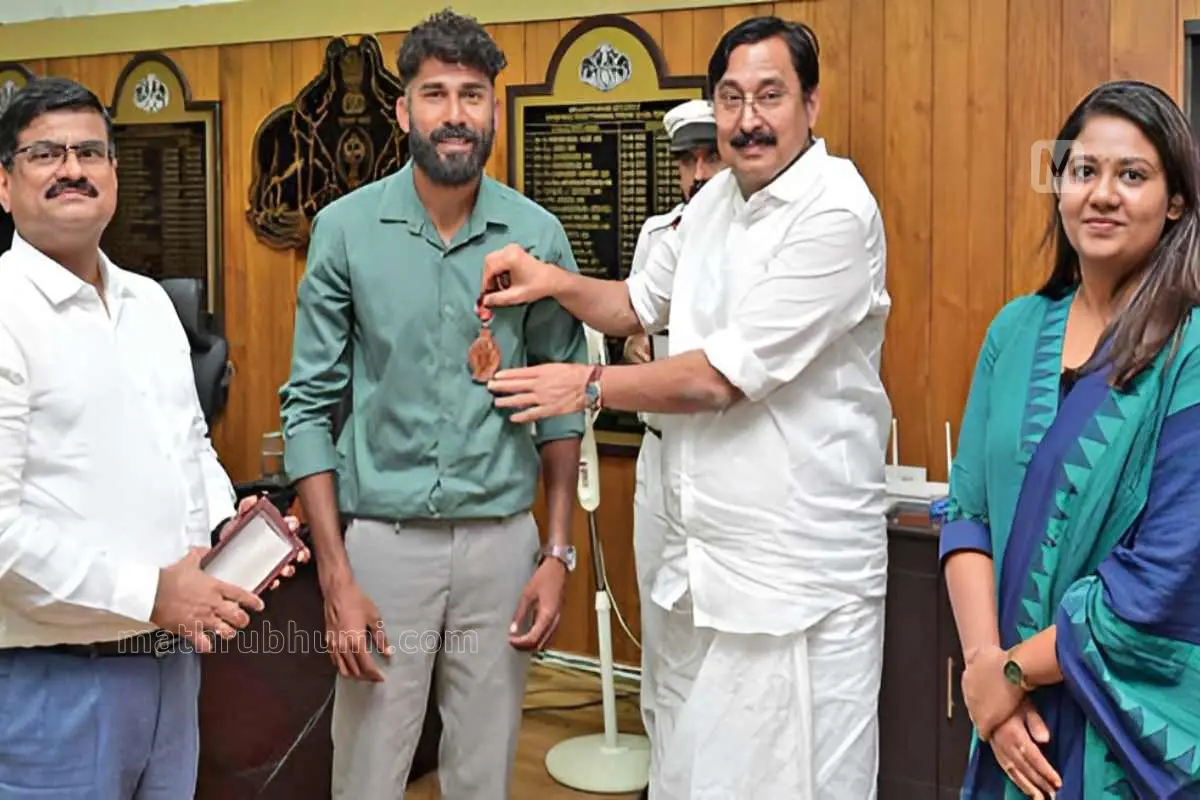 എൻ.കെ. മുഹമ്മദ് ഹാഷിറിന് മന്ത്രി വി. അബ്ദുറഹ്മാൻ ജീവൻരക്ഷാ പതക് അവാർഡ് സമ്മാനിക്കുന്നു. കളക്ടർ വി.ആർ. വിനോദ് സമീപം