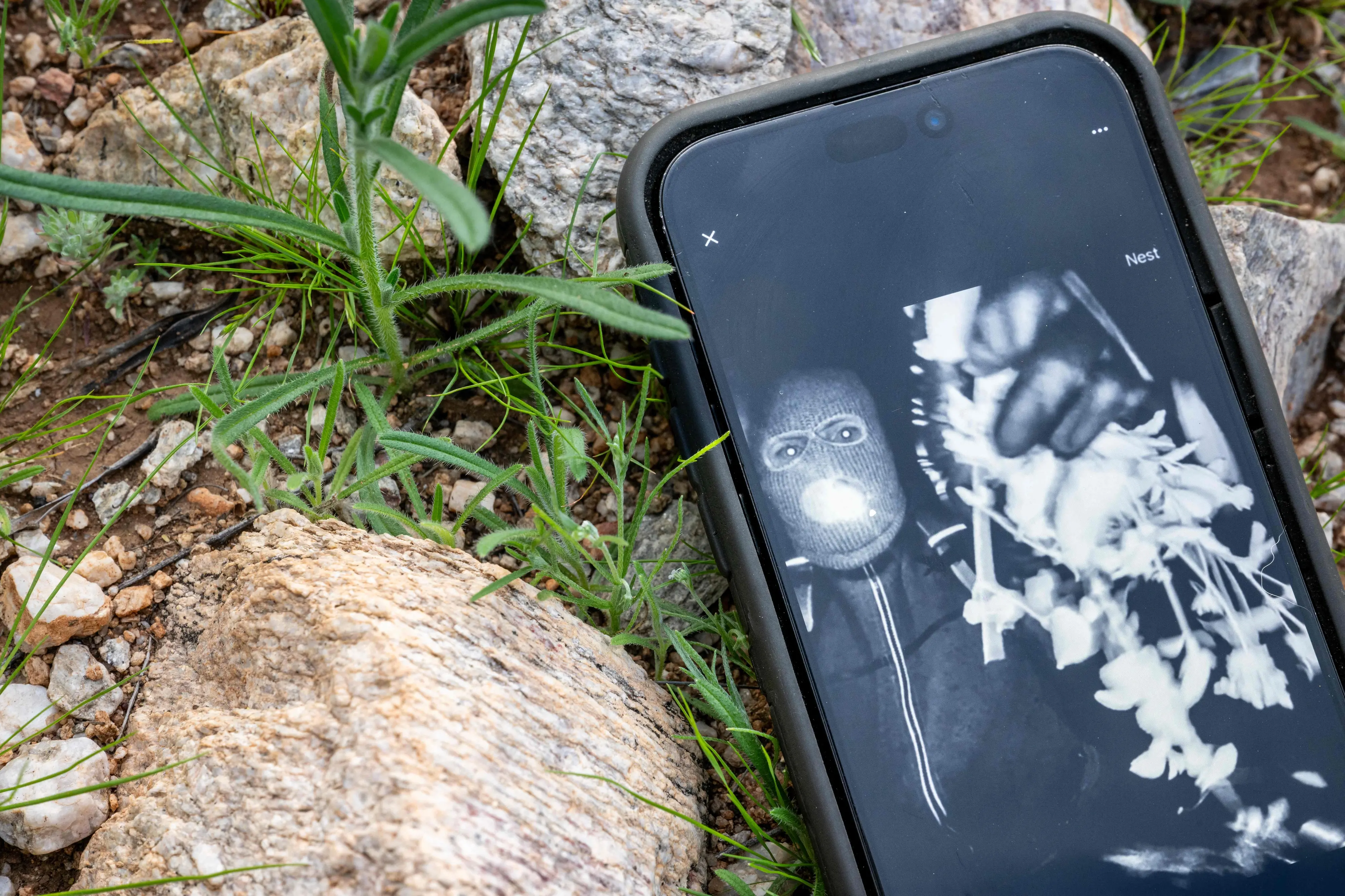 In this photo illustration, Nancy Guthrie's alleged kidnapper is seen on FBI Director Kash Patel's X account on a cellular phone | AFP