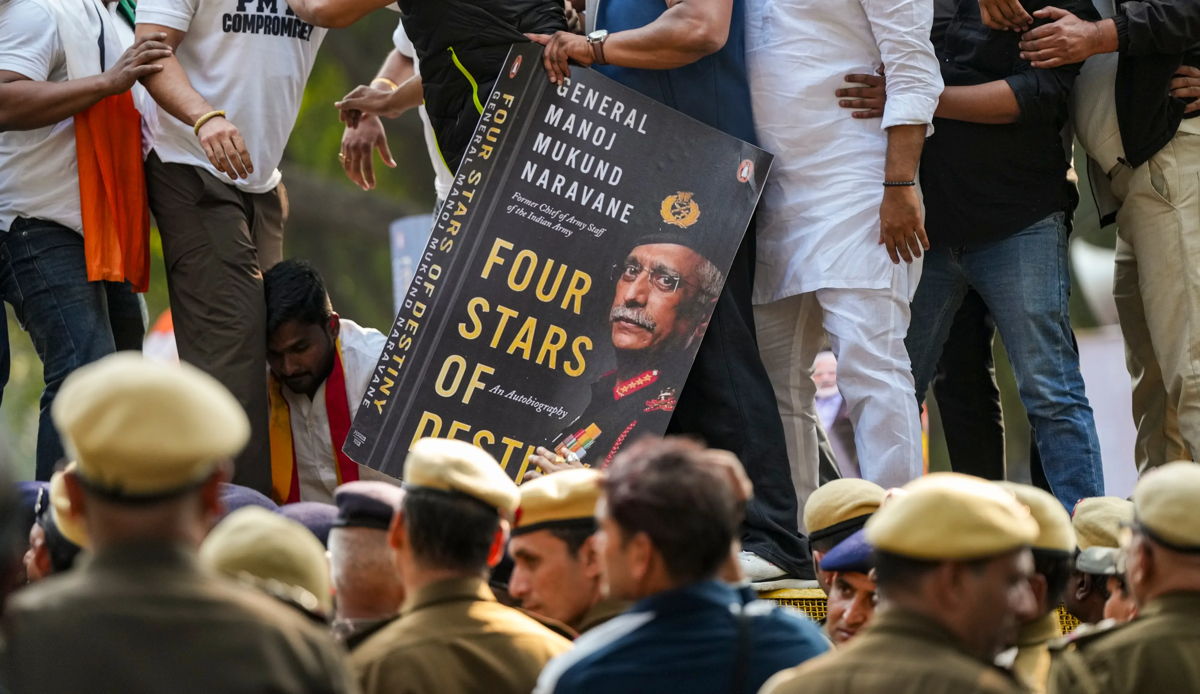 Members of the Indian Youth Congress hold a placard depicting the cover of an unreleased book titled 'Four Stars of Destiny' by former Army chief General Manoj Mukund Naravane | PTI