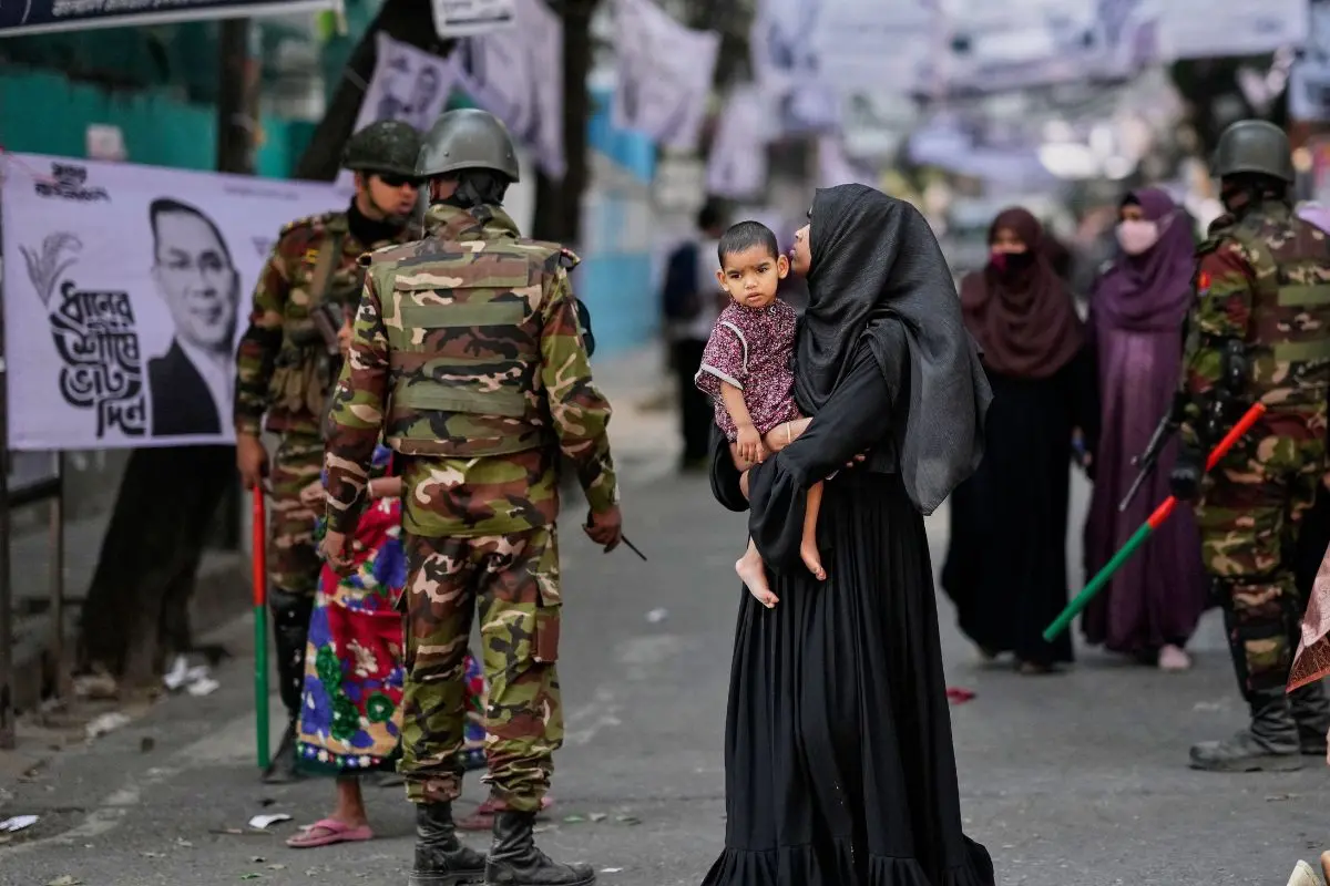 Bangladeshi women leave after casting their votes as security personnel stand guard outside a polling station during the parliamentary election in Dhaka, Bangladesh, Thursday, Feb. 12, 2026. (AP Photo/Anupam Nath)