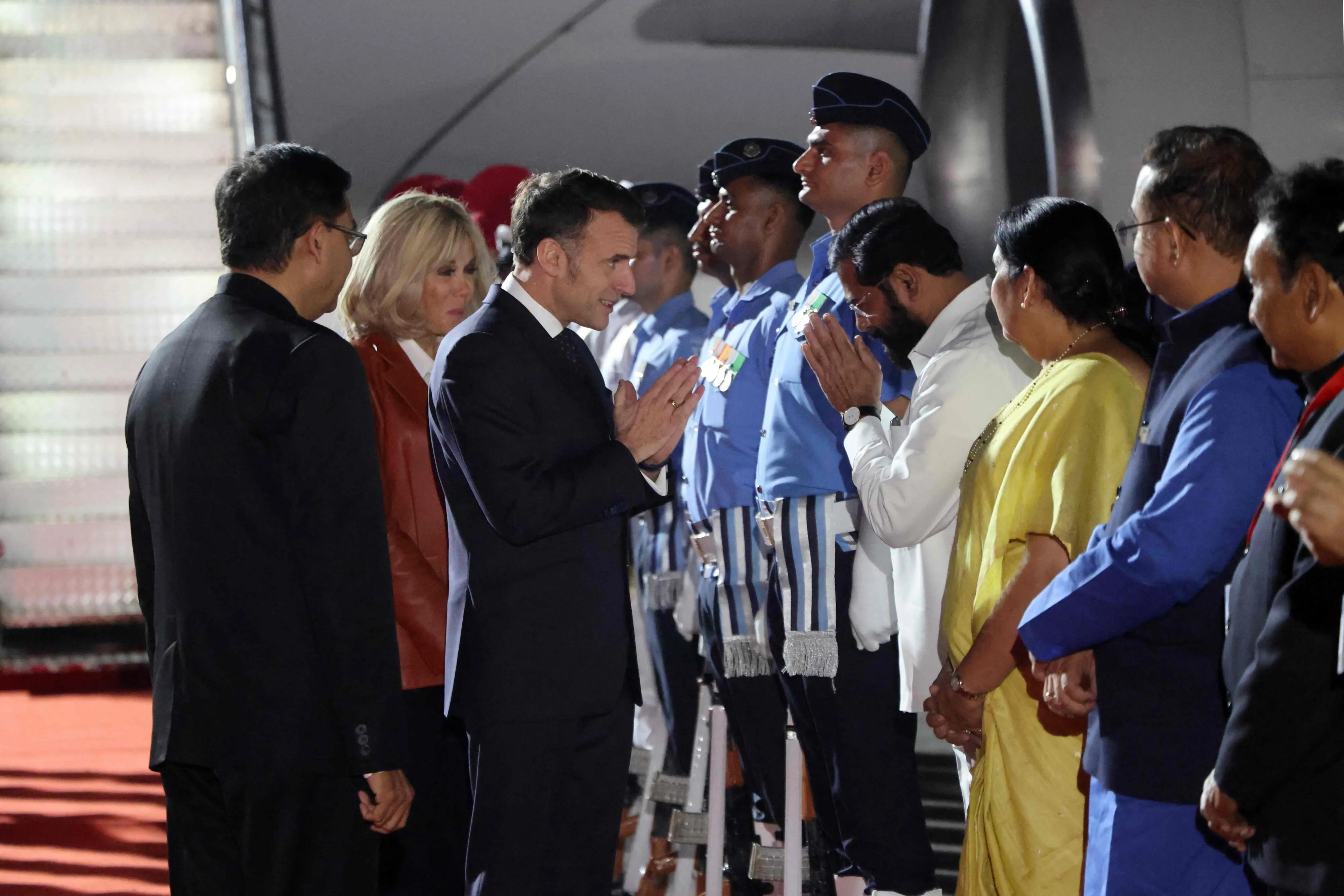 France's President Emmanuel Macron (C-R) and his wife Brigitte Macron (C) are welcomed in Mumbai by Maharashtra Deputy Chief Minister Eknath Shinde and other officials | Photo: AFP