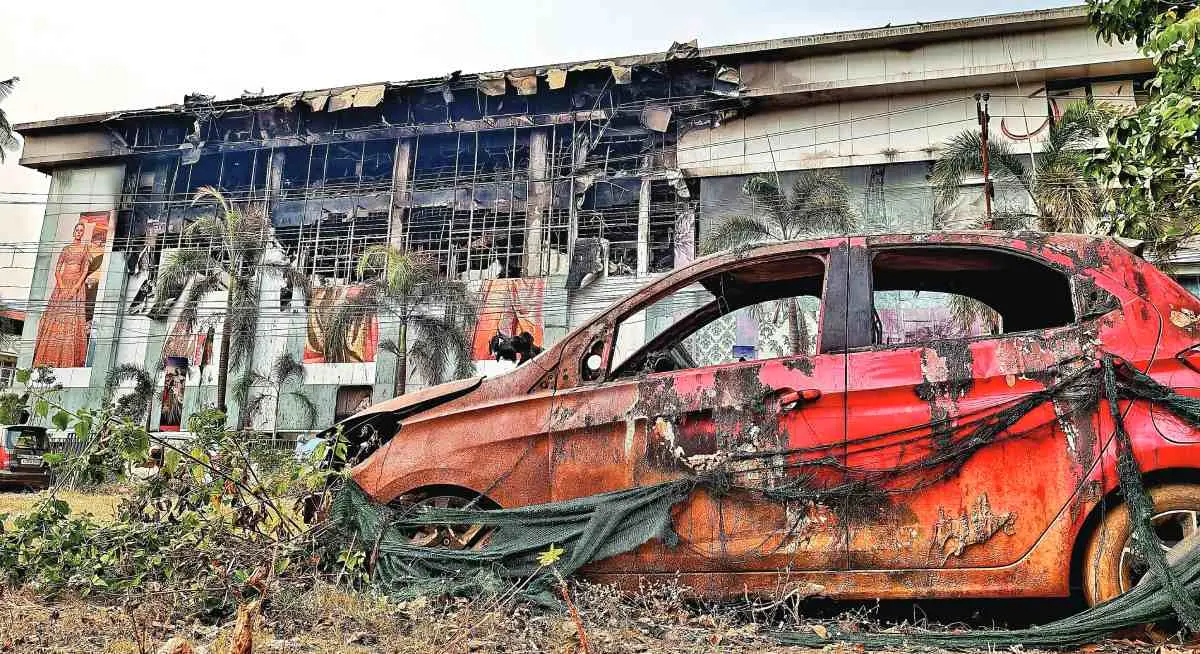 2023-ല്‍ ജയലക്ഷ്മി സില്‍ക്‌സിലുണ്ടായ തീപ്പിടിത്തത്തില്‍ കെട്ടിടത്തിനുസമീപത്തുനിന്ന് തീപടര്‍ന്ന് കത്തിനശിച്ച കാര്‍, പുറുകുവശത്ത് ചൊവ്വാഴ്ചത്തെ തീപ്പിടിടത്തില്‍ രണ്ടാം തവണയും കത്തിയമര്‍ന്ന ജയലക്ഷ്മി സില്‍ക്‌സും കാണാം