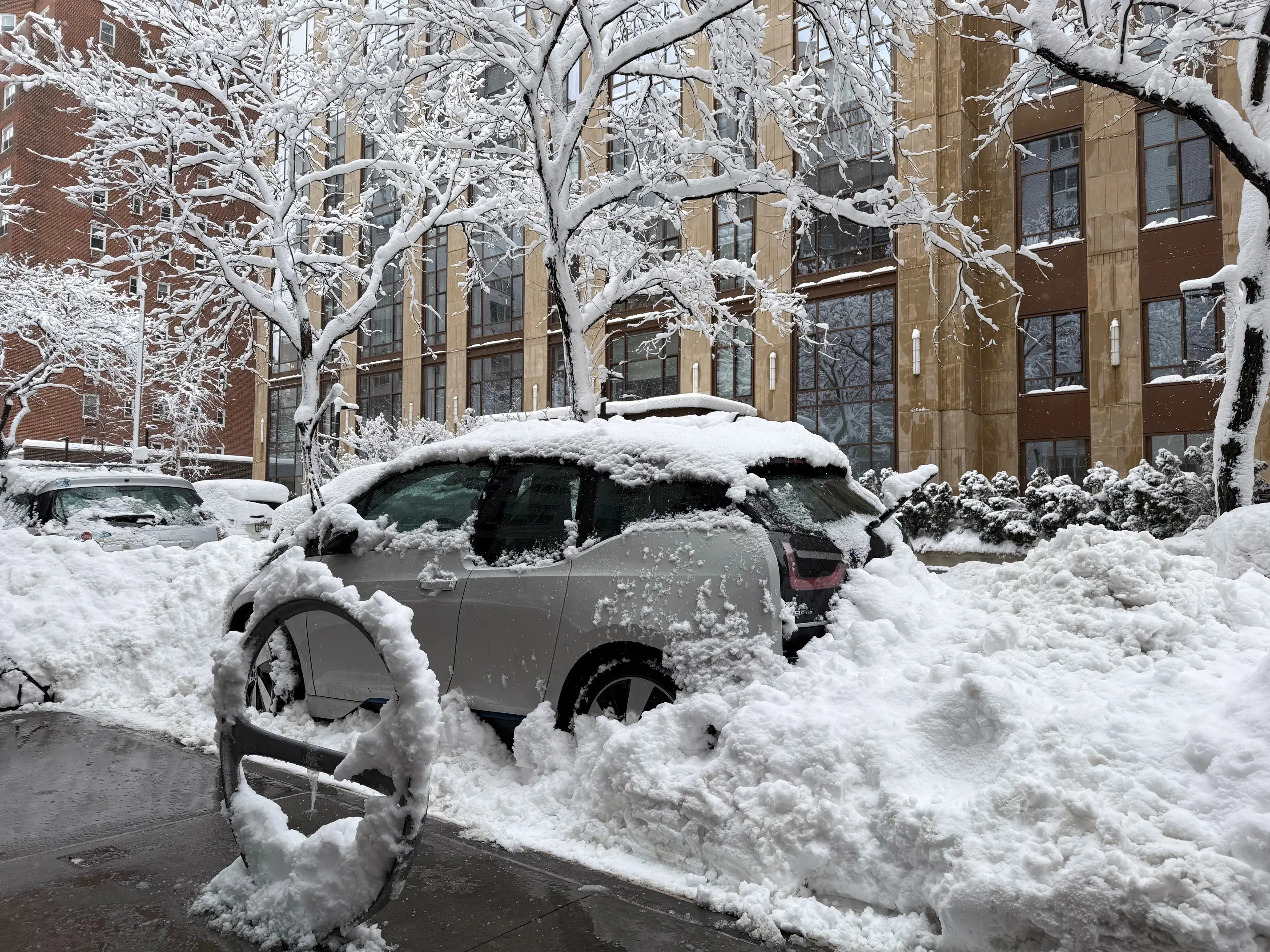 Cars laden with snow are parked in mounds of snow on East 19th Street, Monday, Feb. 23, 2026, in New York. (AP Photo/Pamela Hassell)