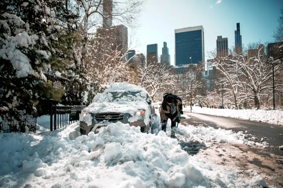 A man shovels snow to take out his car parked in Central Park a day after a winter storm on Tuesday