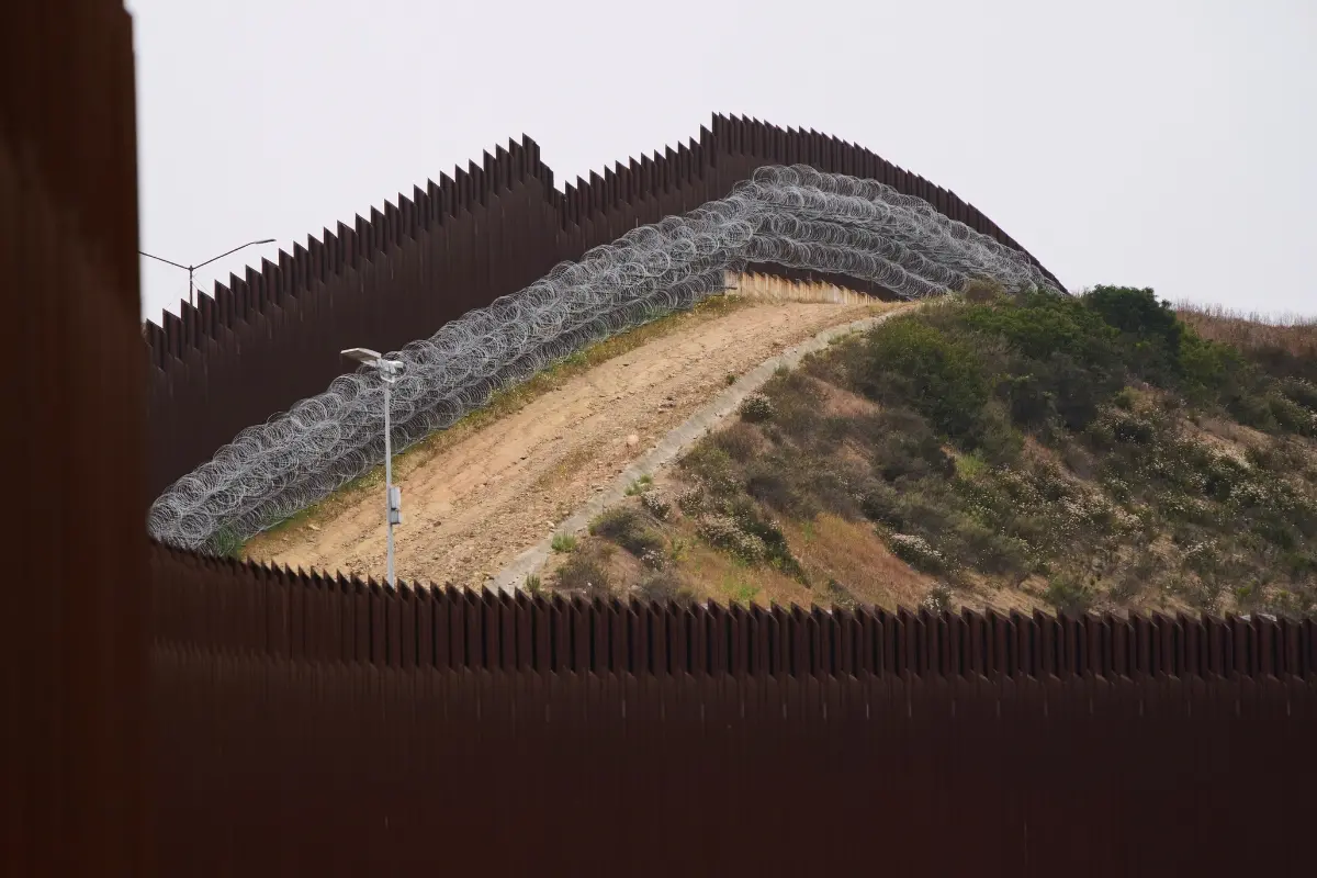 Concertina wire lines the interior of a border wall separating Tijuana, Mexico, from the United States.| Photo: AP