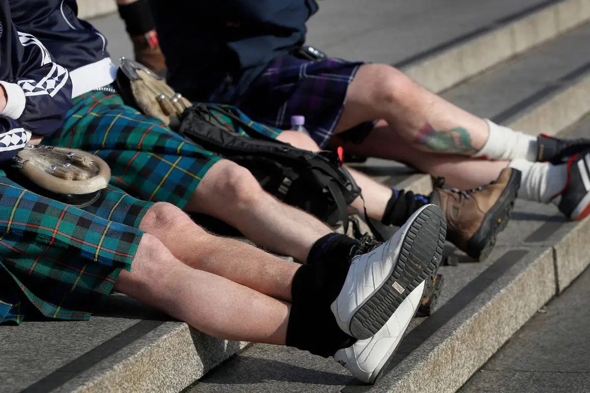 Scottish soccer fans wearing kilts sit on the steps in Trafalgar Square in London. | File Photo: AP