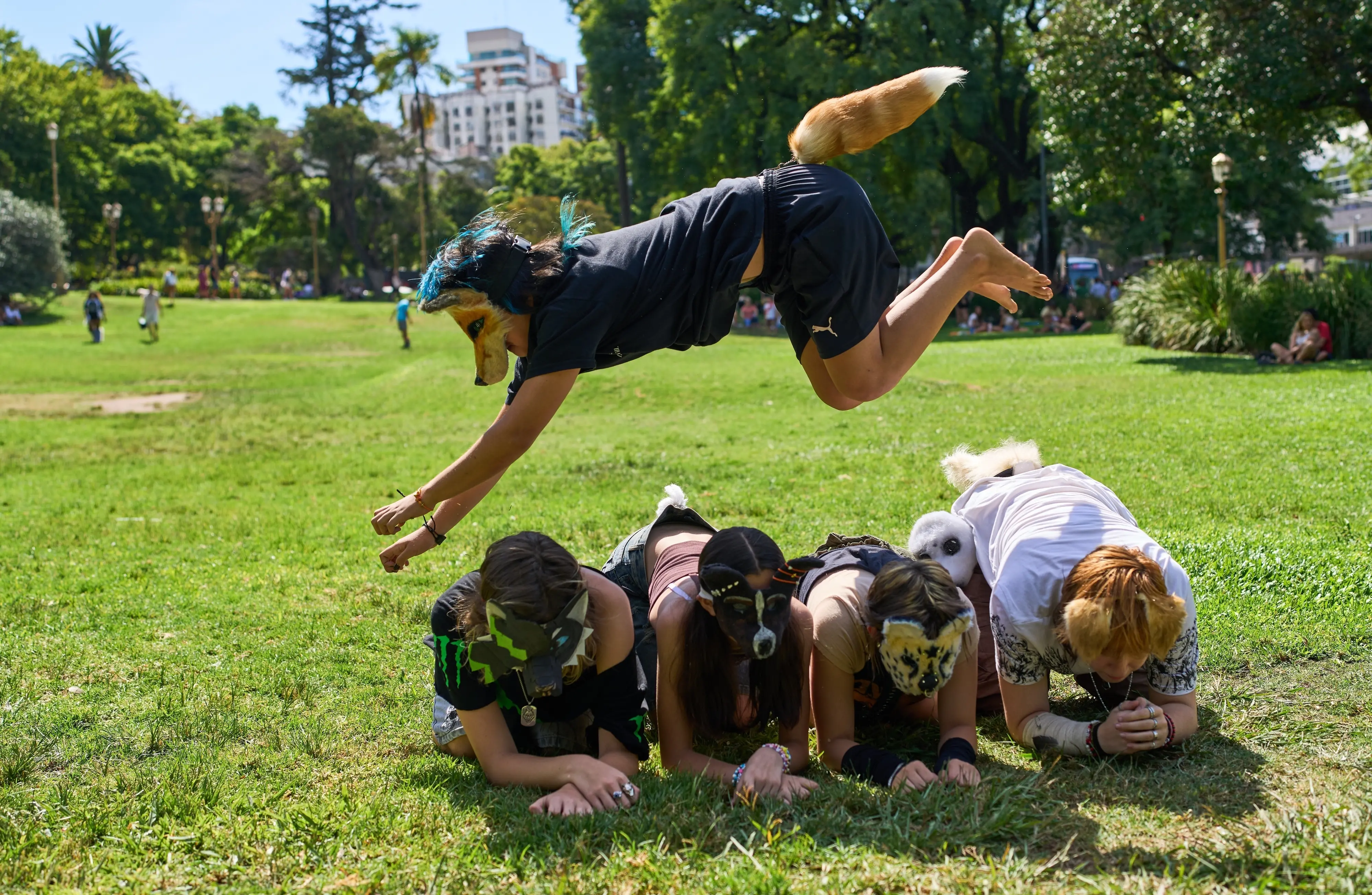 A youth jumps over other therians, people who say they identify as non-human animals, during a gathering in a square in Buenos Aires, Argentina | AP