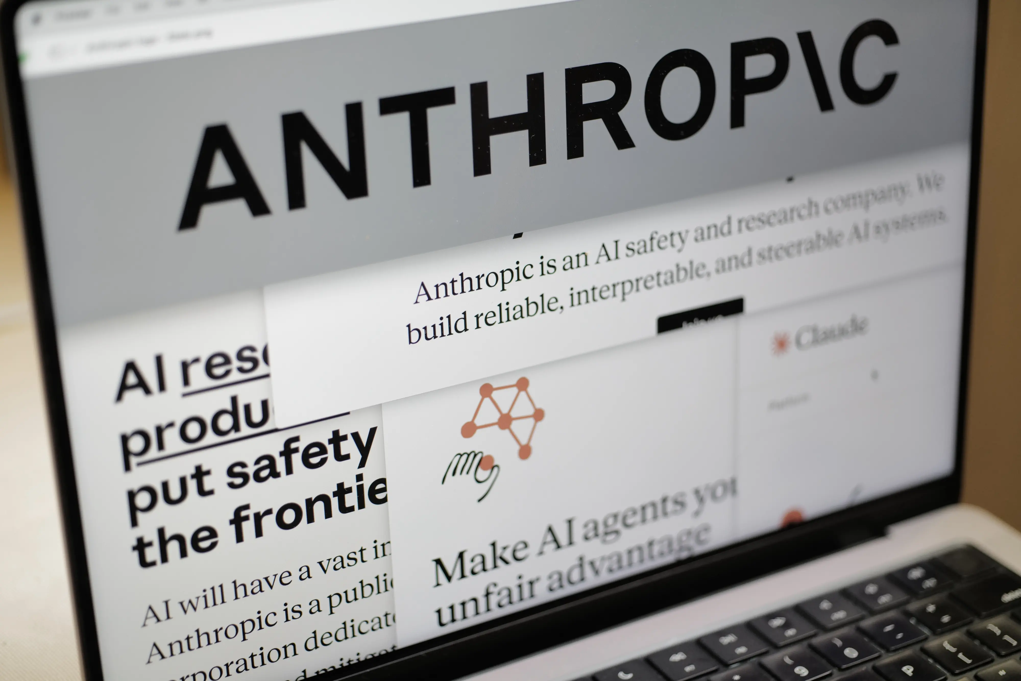 Pages from the Anthropic website and the company's logo are displayed on a computer screen | AP