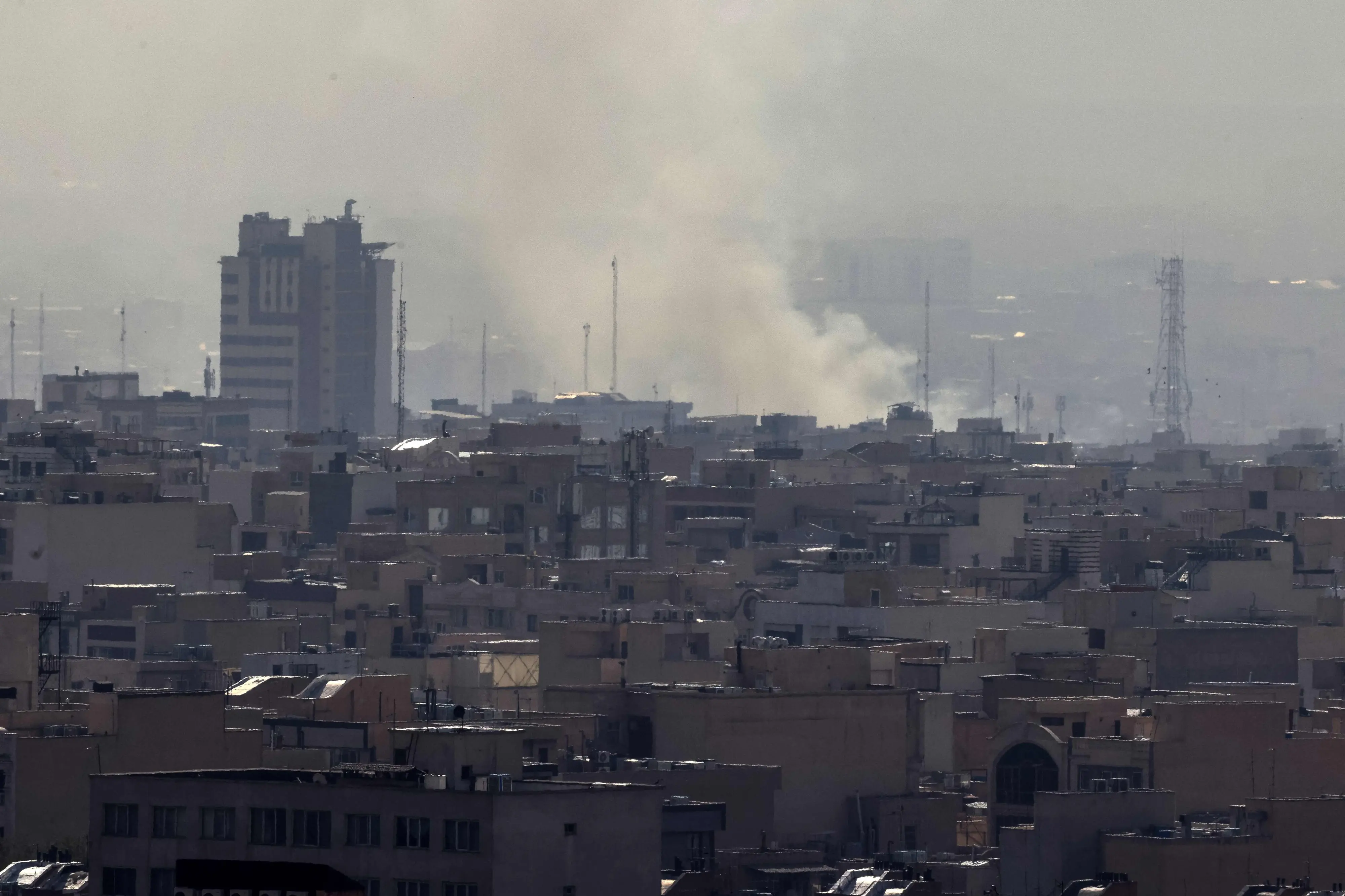 A plume of smoke rises following a reported explosion in Tehran | AFP