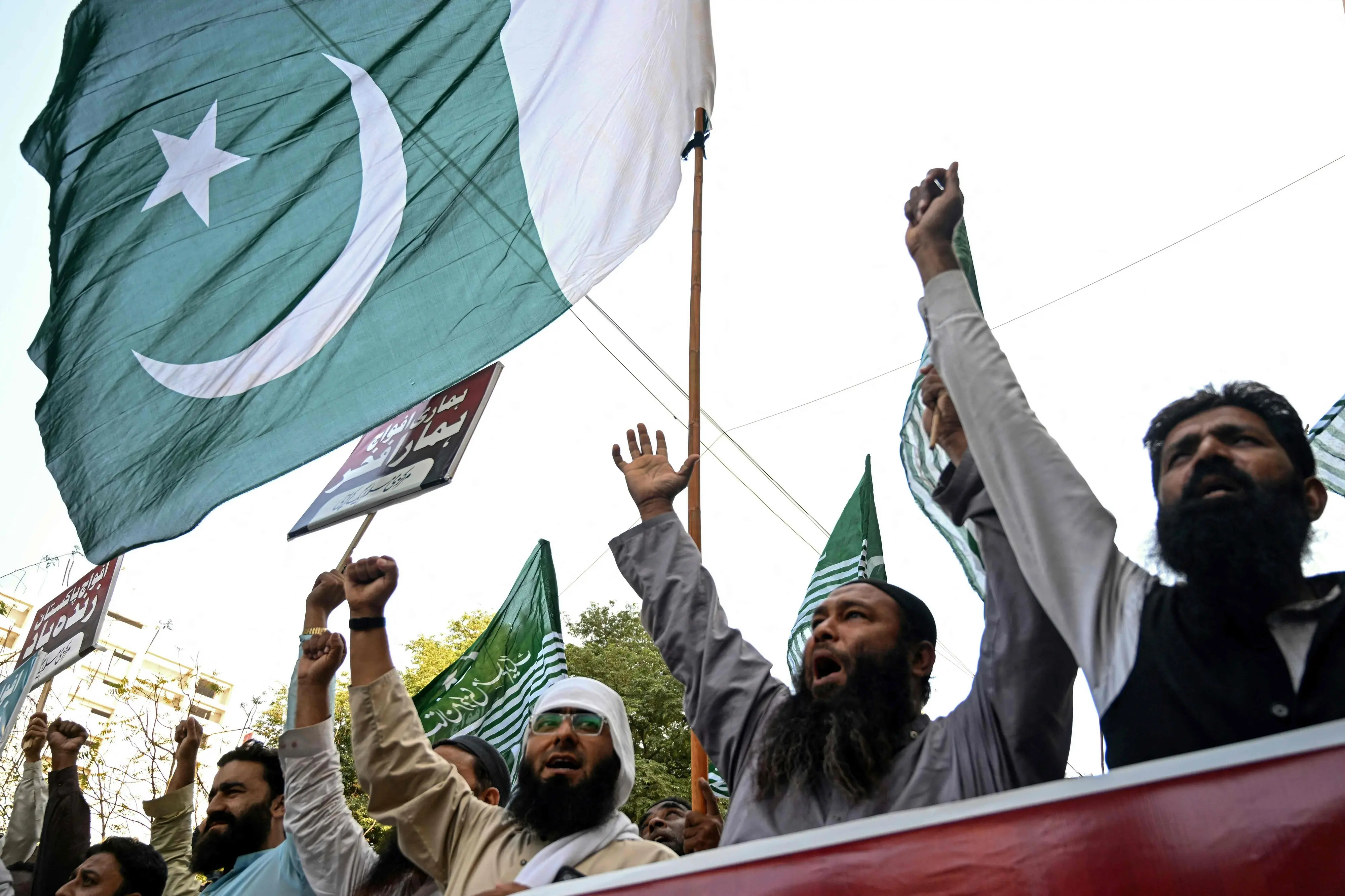 Pakistan Markazi Muslim League (PMML) activists wave the country's national flag